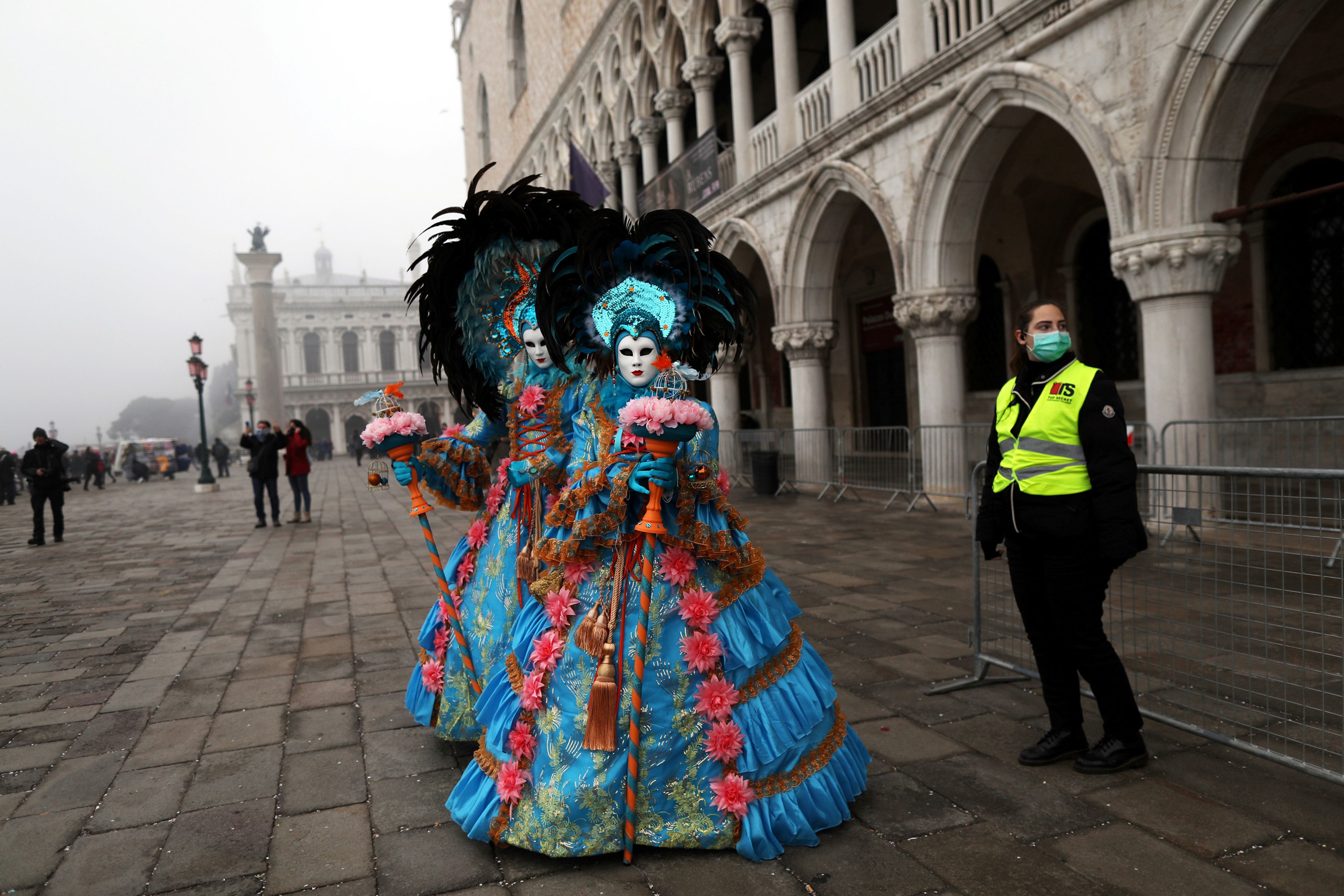 Personas disfrazadas pasean por la plaza de San Marcos en Venecia en medio del brote del coronavirus, que ha cancelado los actos oficiales del carnaval.