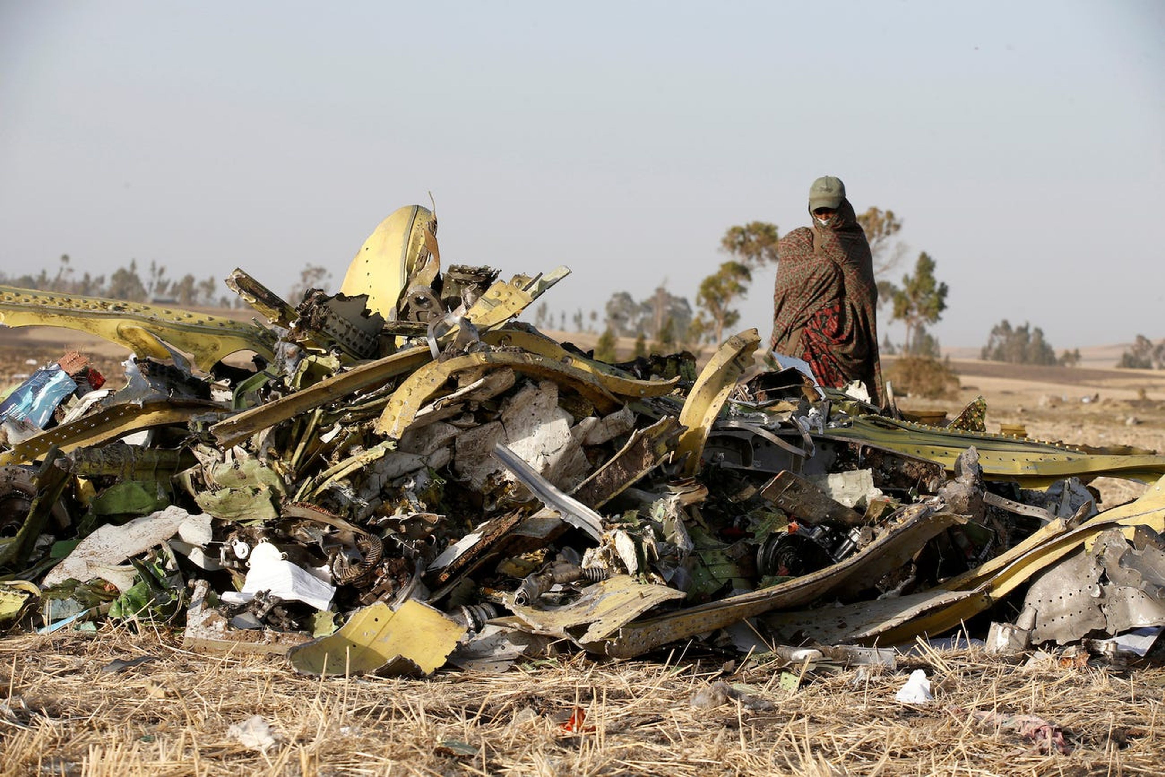 Un policía etíope camina al lado de los escombros del avión ET 302 de Ethiopian Airlines que se estrelló en marzo de 2019.