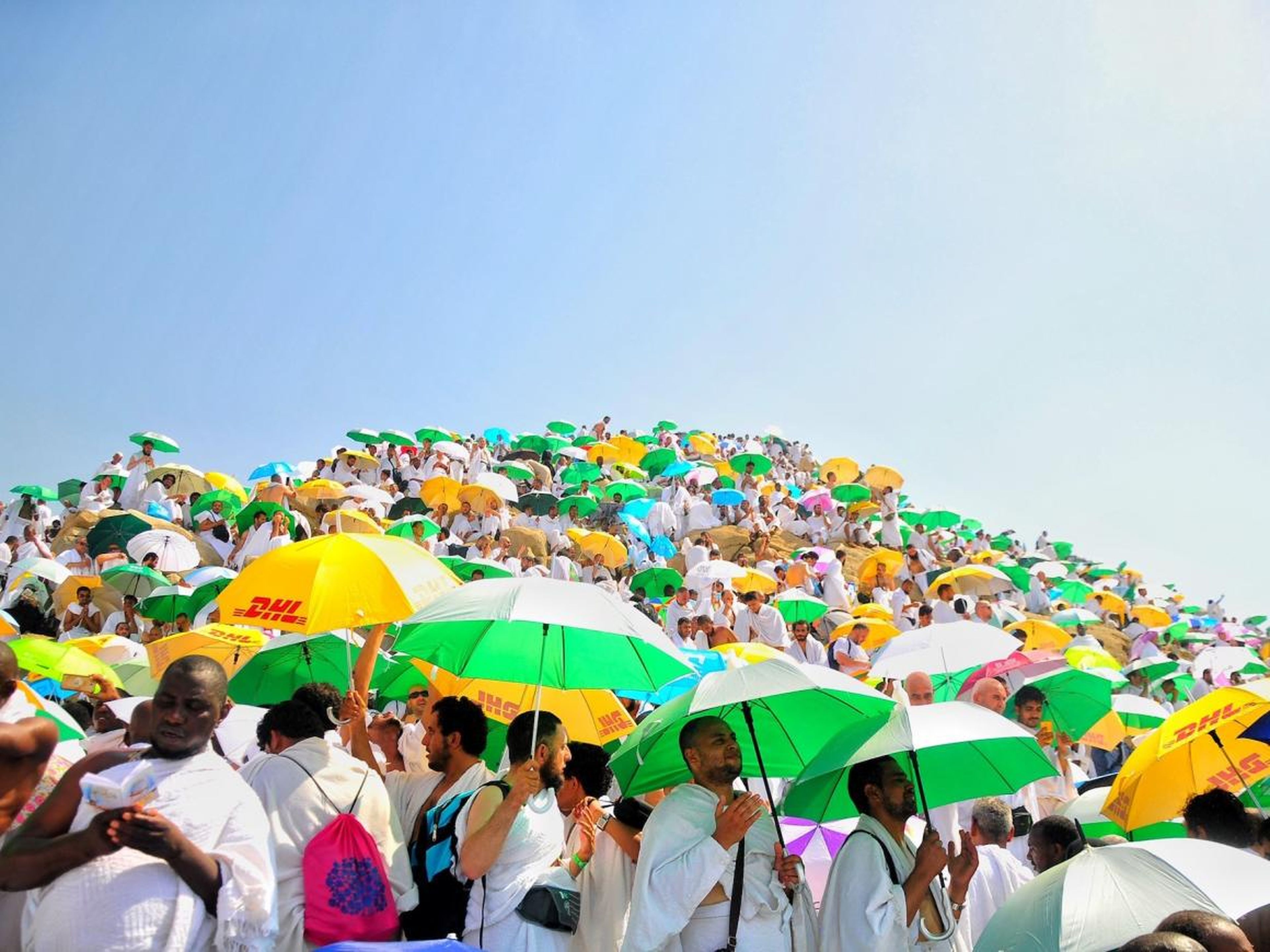 Los peregrinos musulmanes suelen llevar paraguas para protegerse del sol.