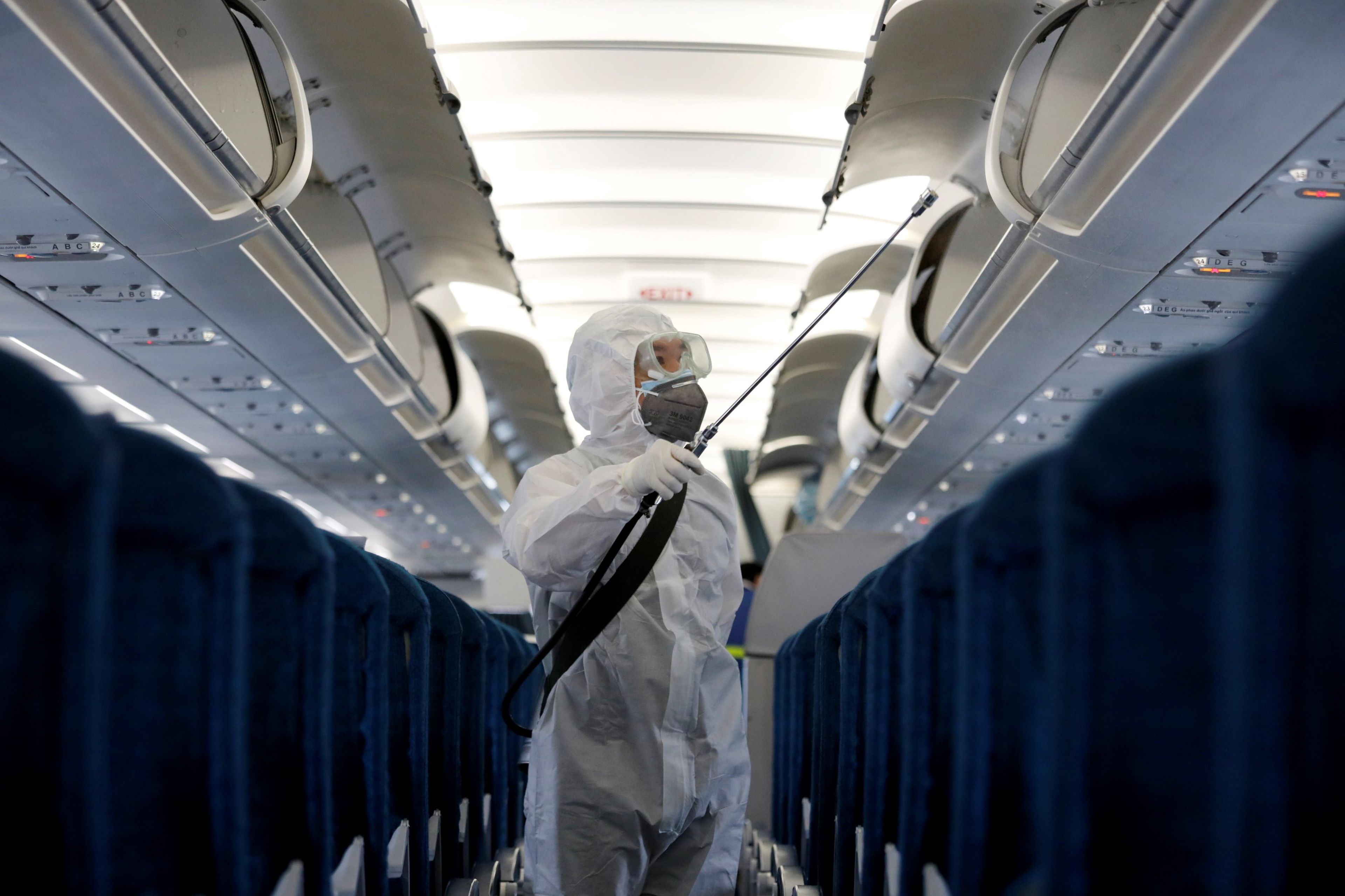 Un trabajador desinfecta un avión por el medio a infecciones por el brote del coronavirus de Wuhan