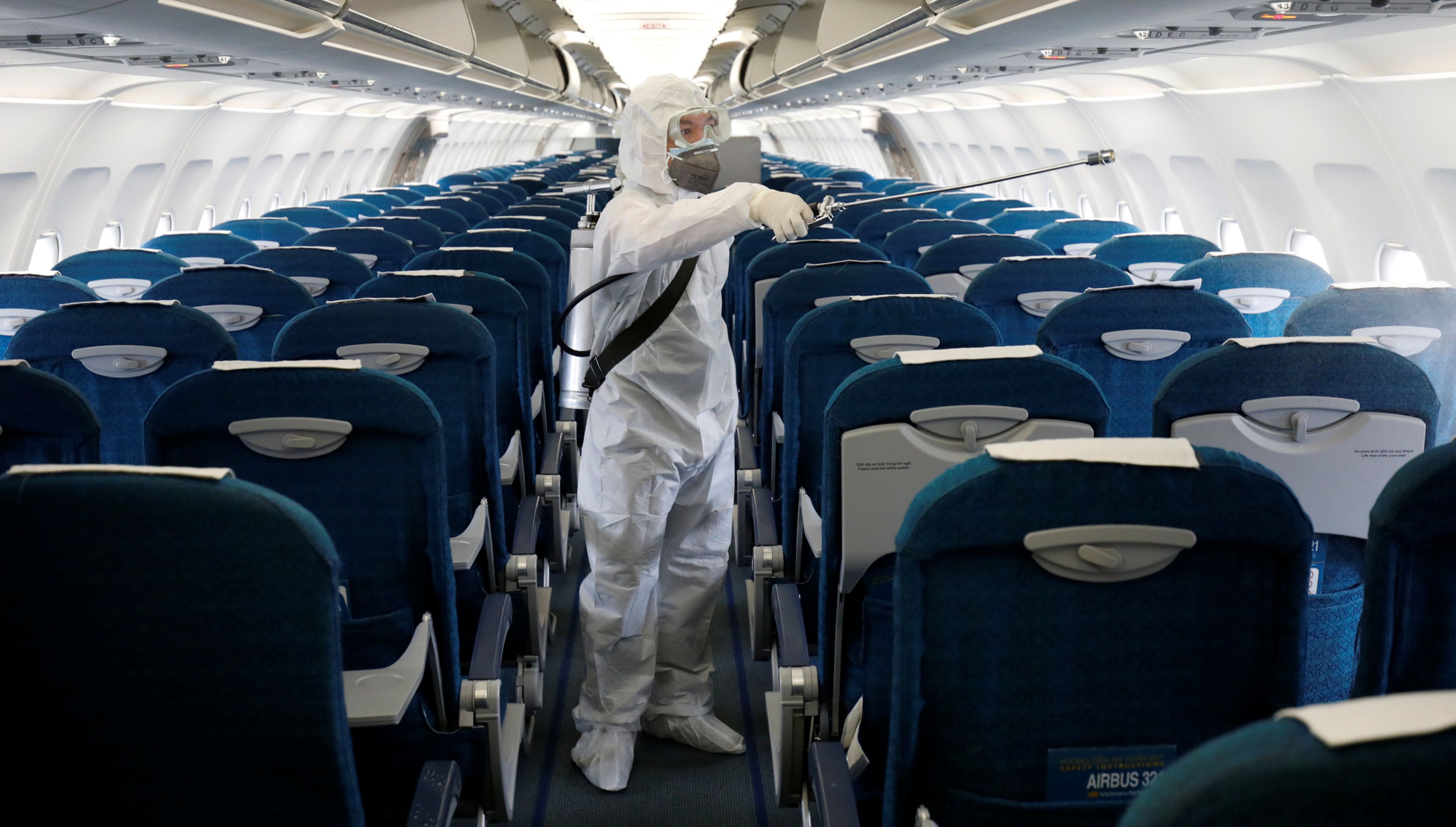 Un trabajador sanitario desinfecta un avión de Vietnam Airlines en el aeropuerto de Hanoi