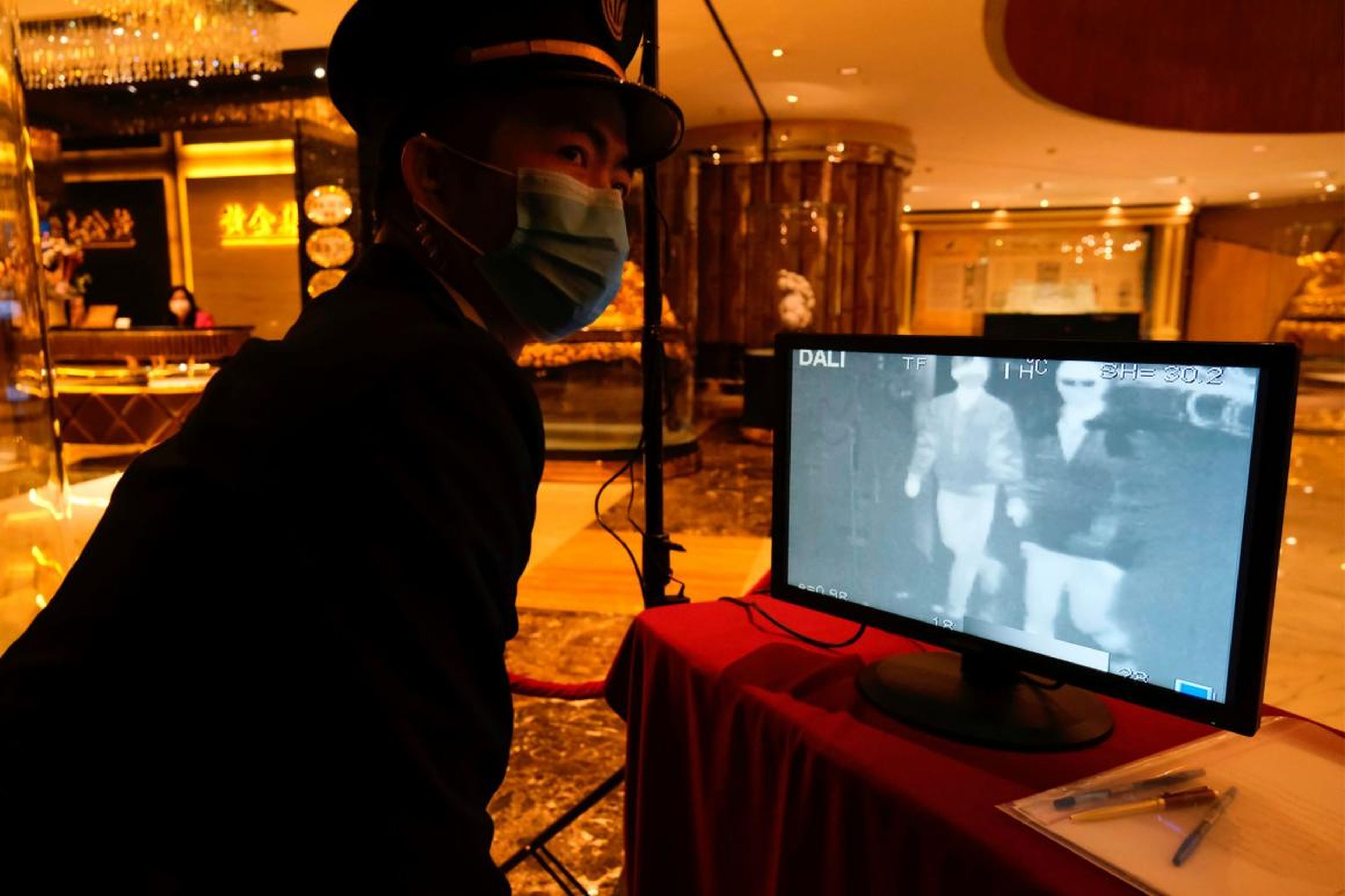 A security guard monitors thermal scanners that detect temperatures of visitors at the closed Grand Lisboa casino and hotel.