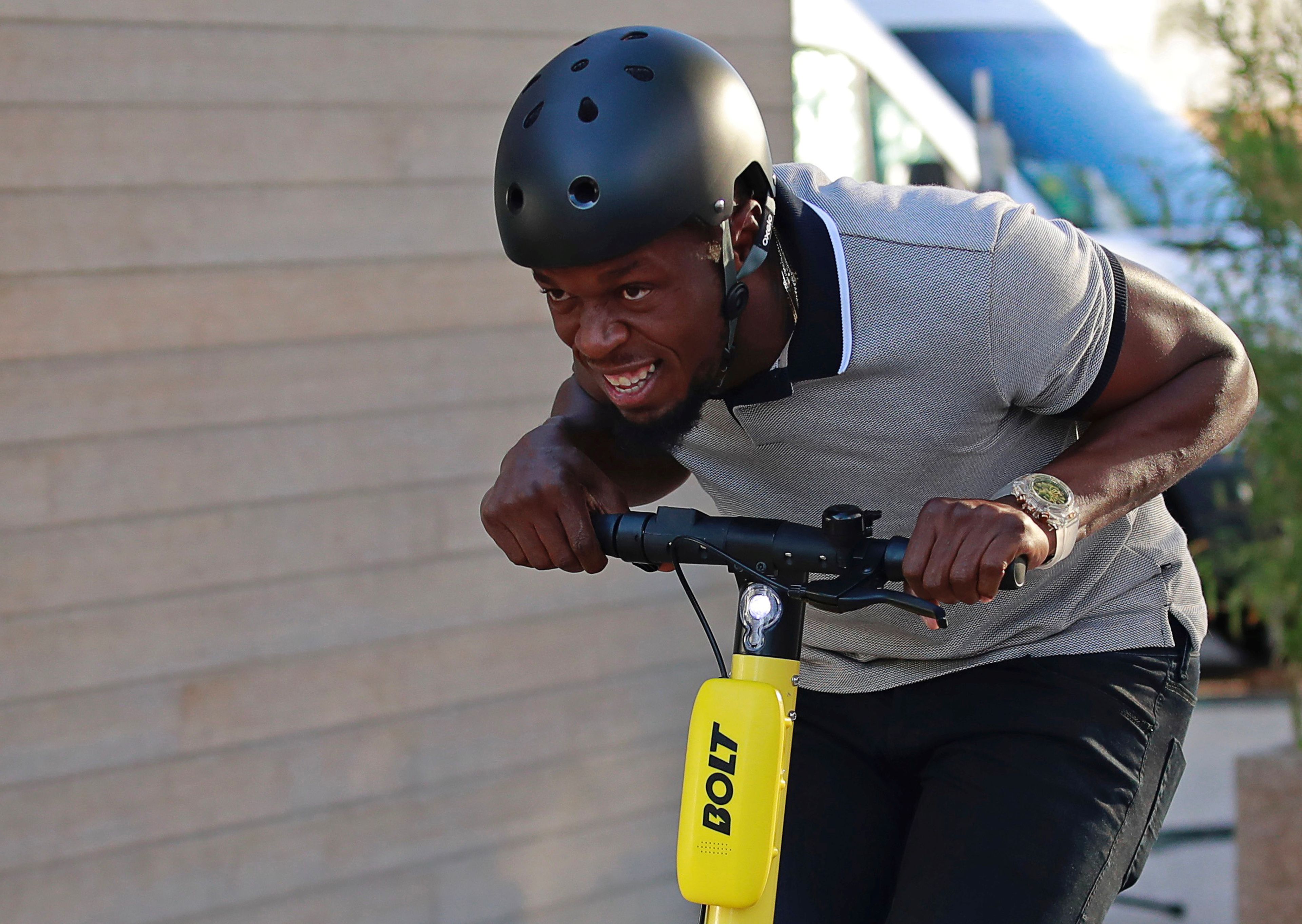 El exatleta Usain Bolt conduce un patinete eléctrico compartido de la marca Bolt en París.