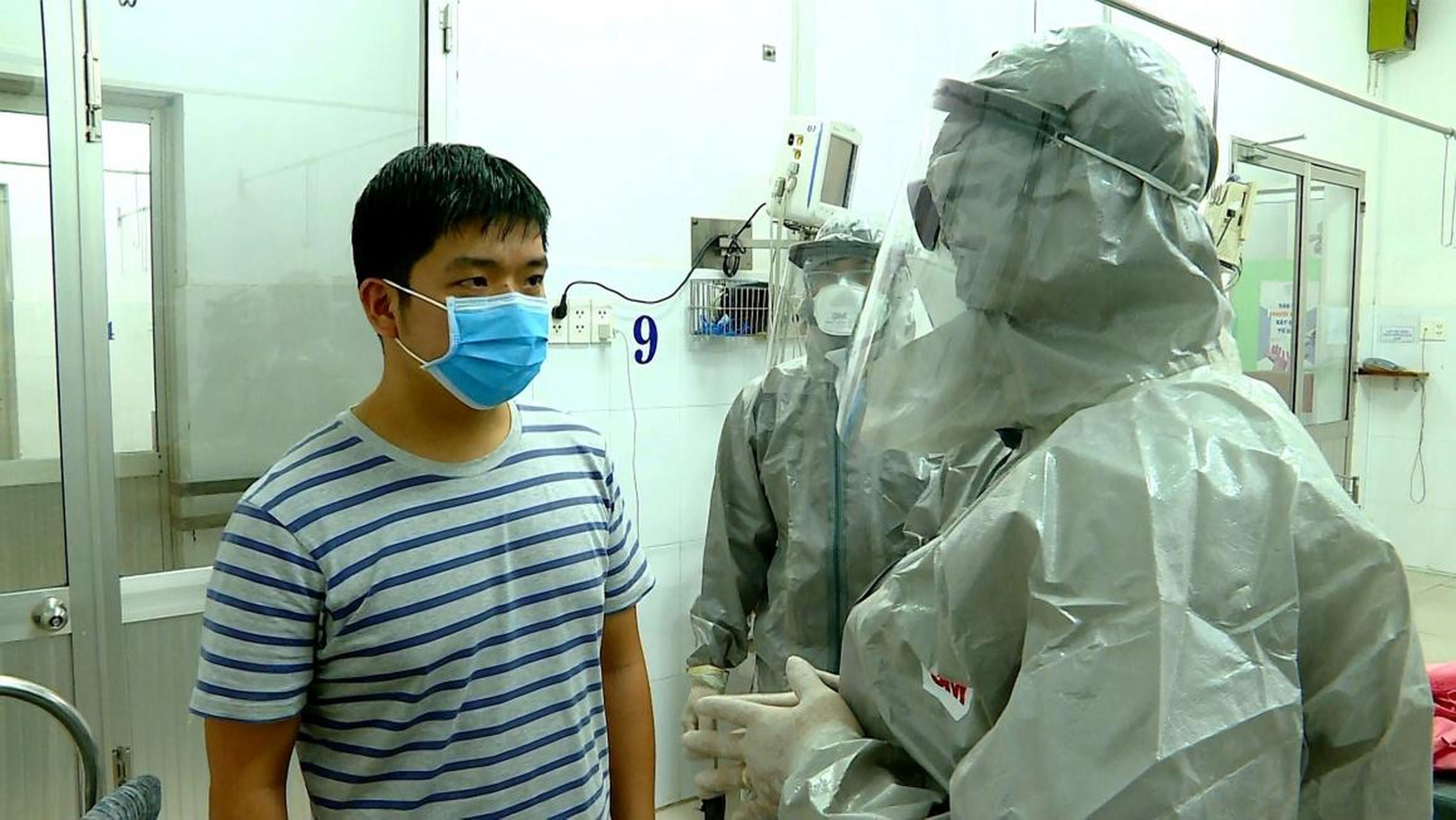Vietnam's vice minister of health, Nguyen Truong Son, talks with a man at an isolated section of a hospital where two Chinese citizens had tested positive for coronavirus, in Ho Chi Minh city.