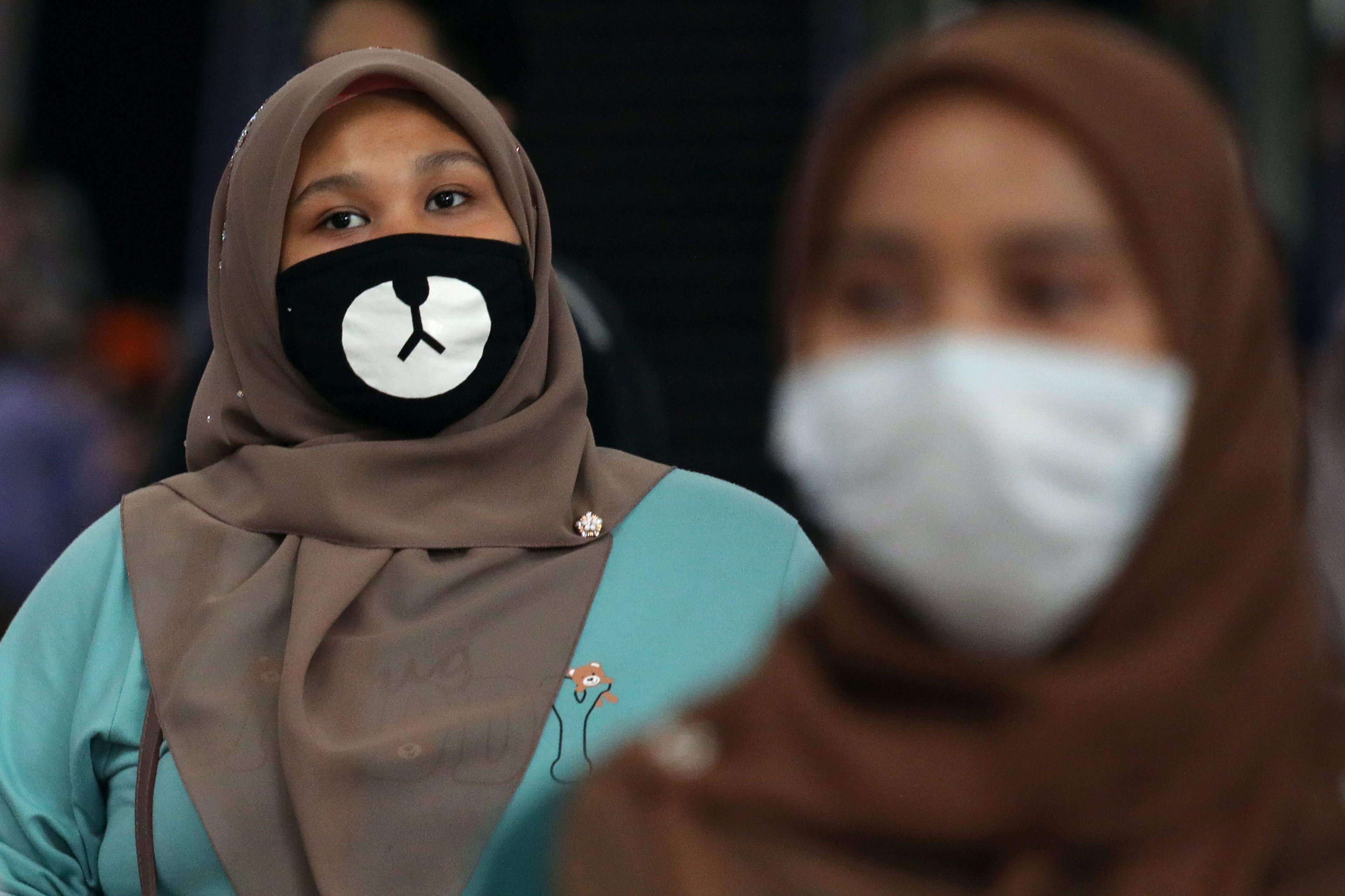 2 mujeres con mascarillas en una estación de Kuala Lumpur (Malasia)