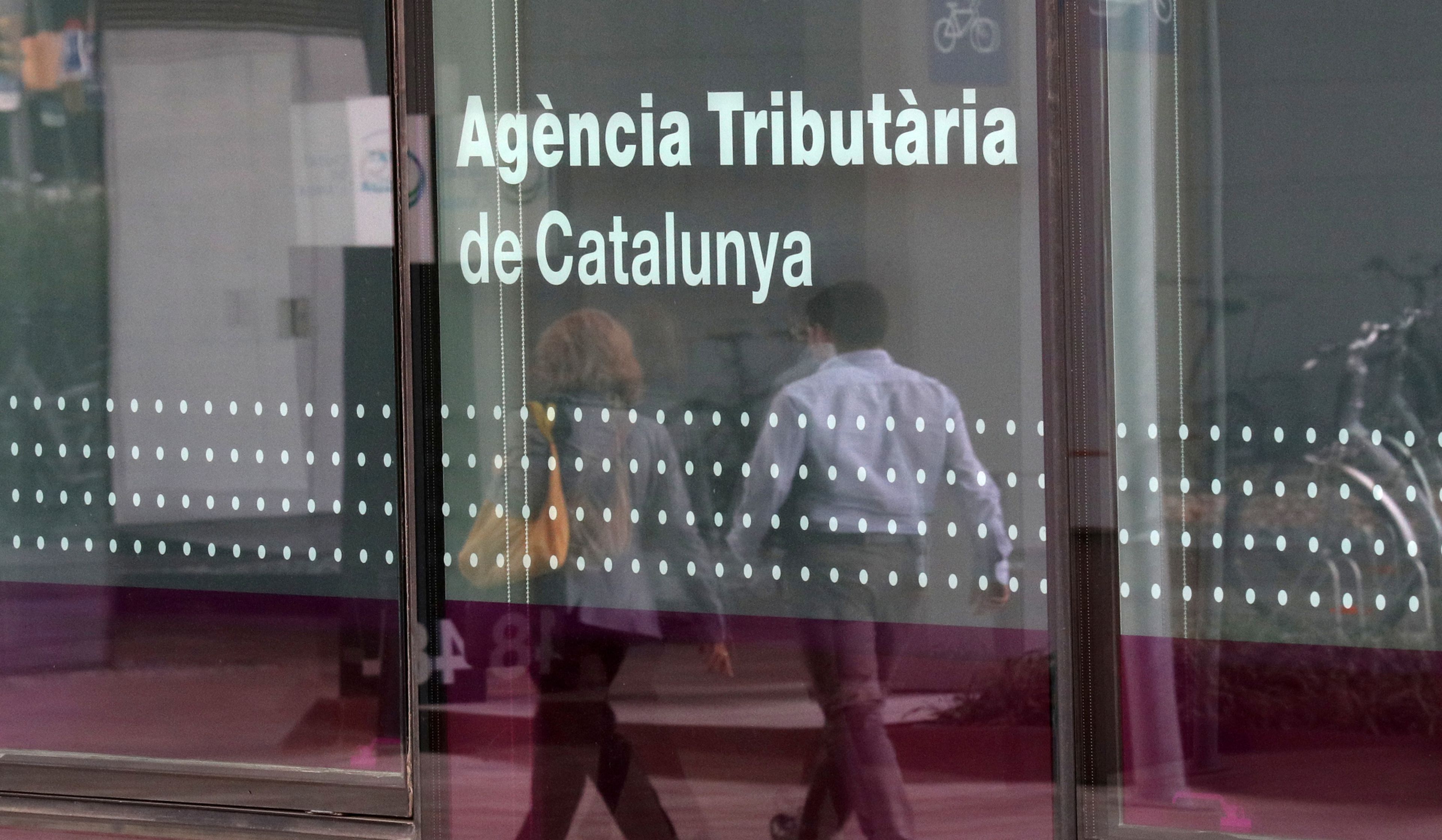 2 personas pasan ante la sede de la Agència Tributària de Catalunya en Barcelona