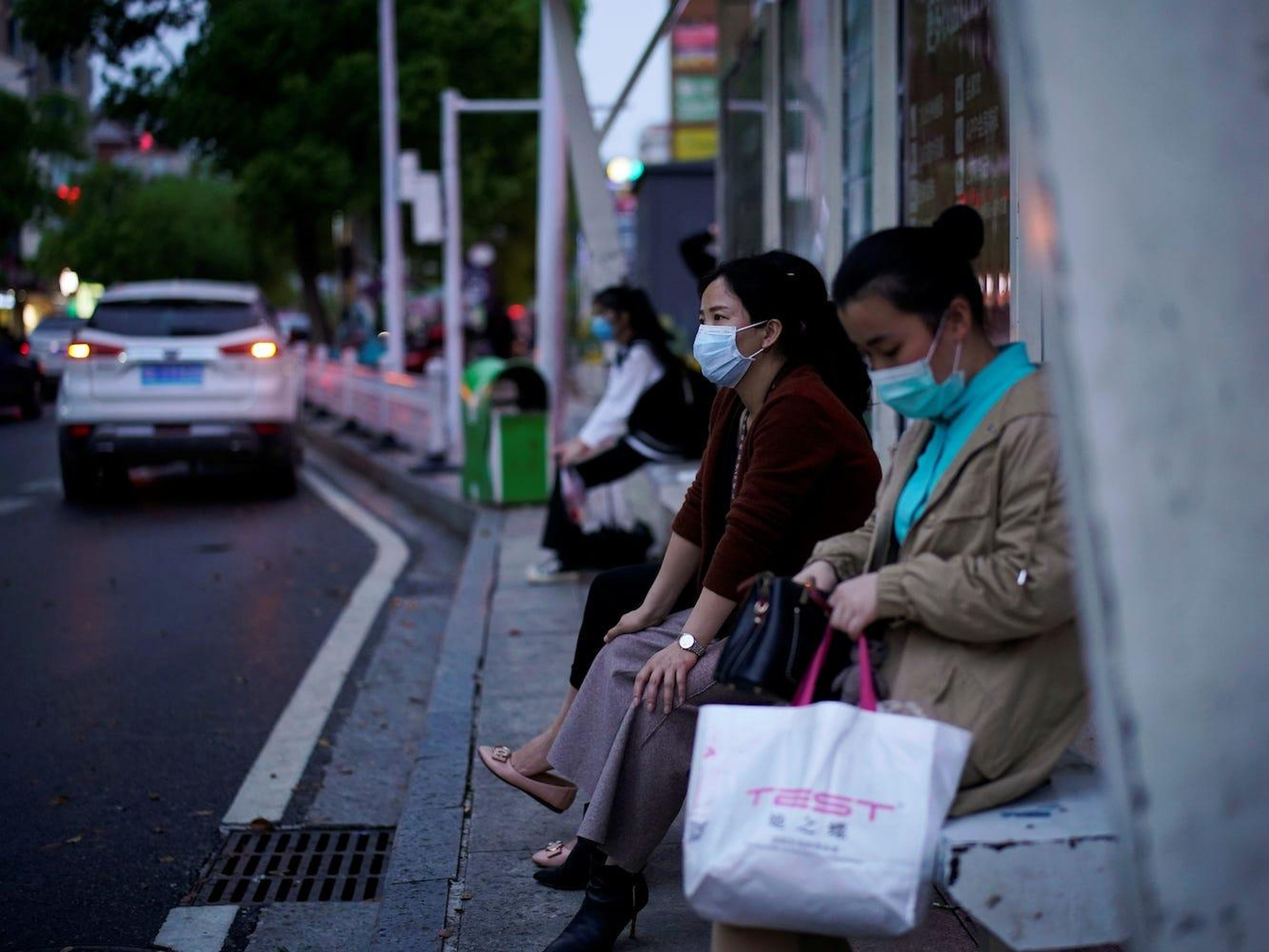 Estas mujeres esperan al autobús en una parada en Xianning, el 25 de marzo de 2020.