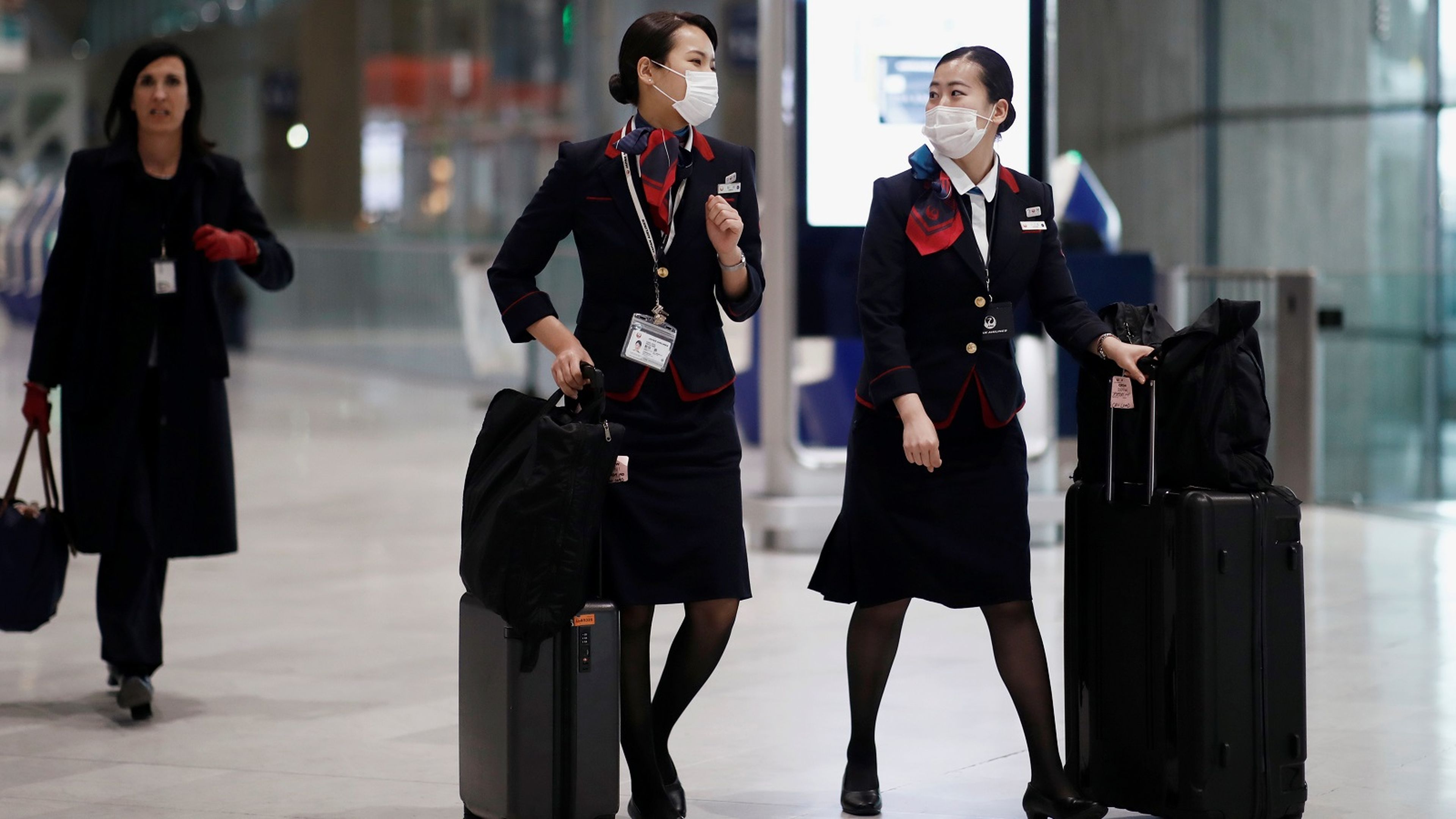 Dos azafatas caminan en un aeropuerto durante el brote de coronavirus.