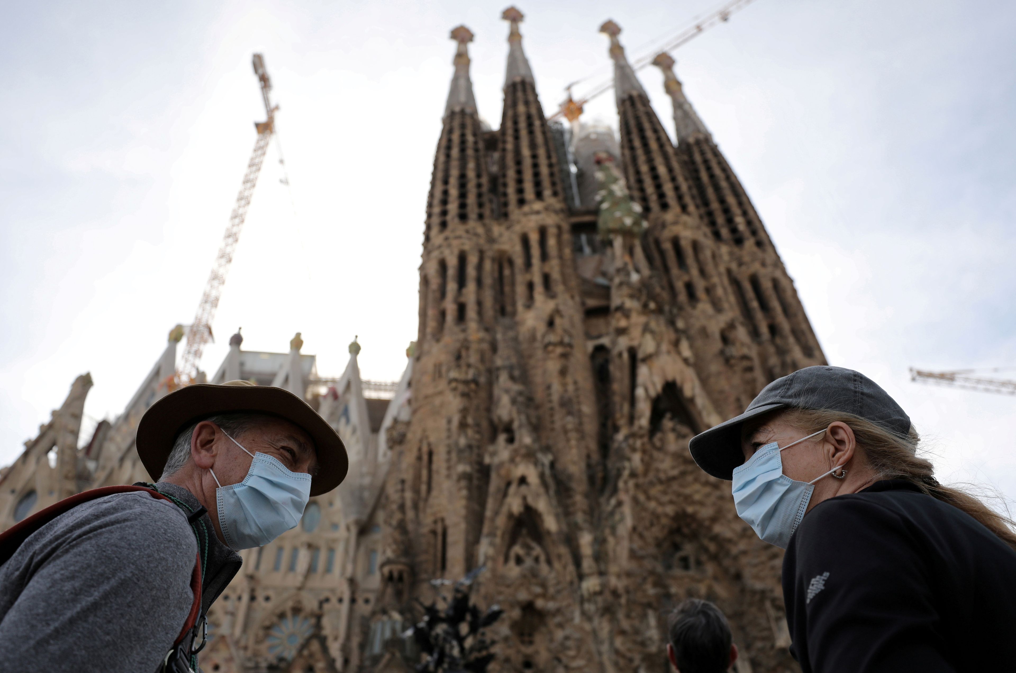 Dos turistas en la Sagrada Familia de Barcelona con mascarillas por el coronavirus.