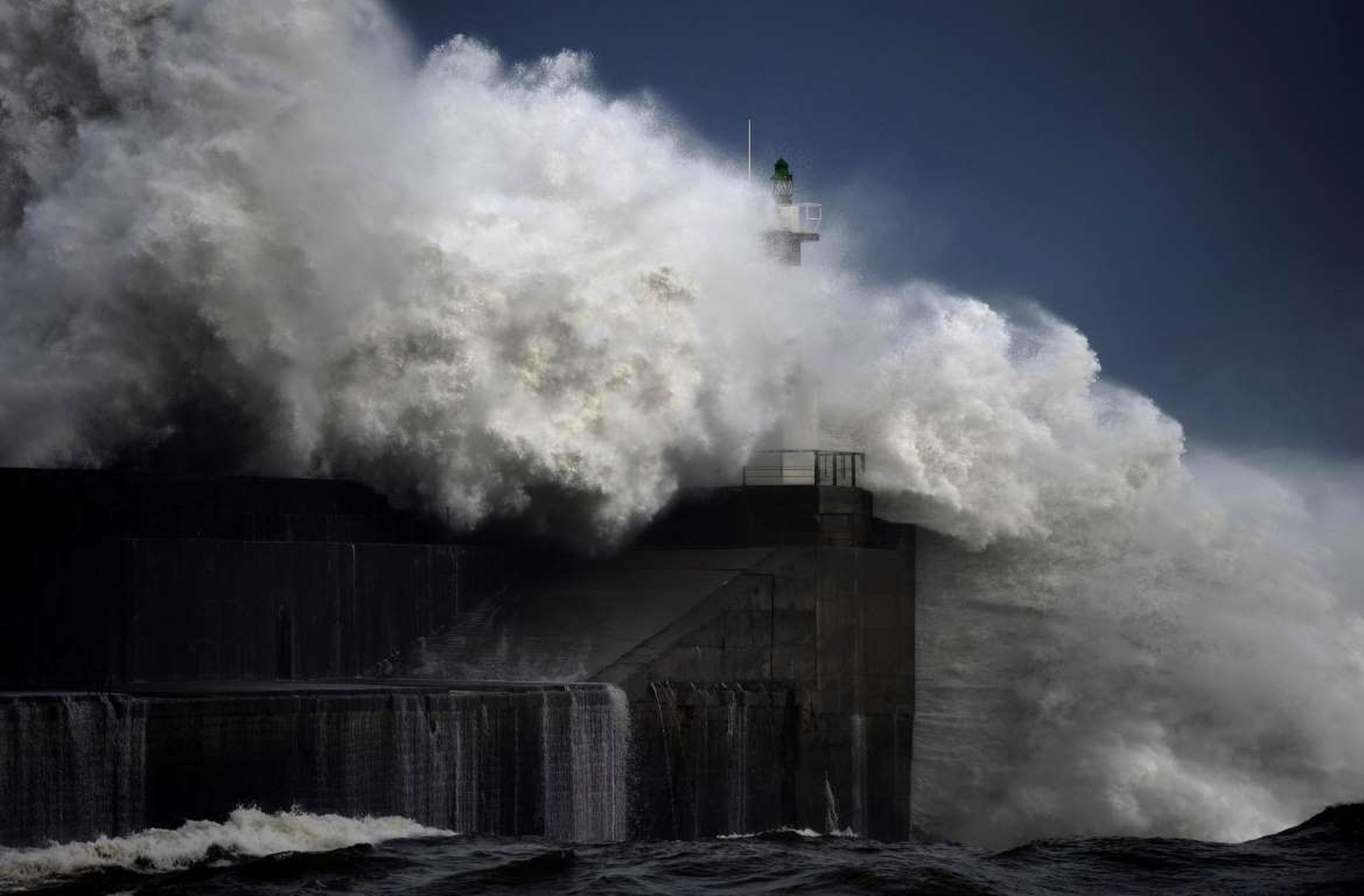 Enormes olas se estrellan contra un puerto marítimo, al norte de España.
