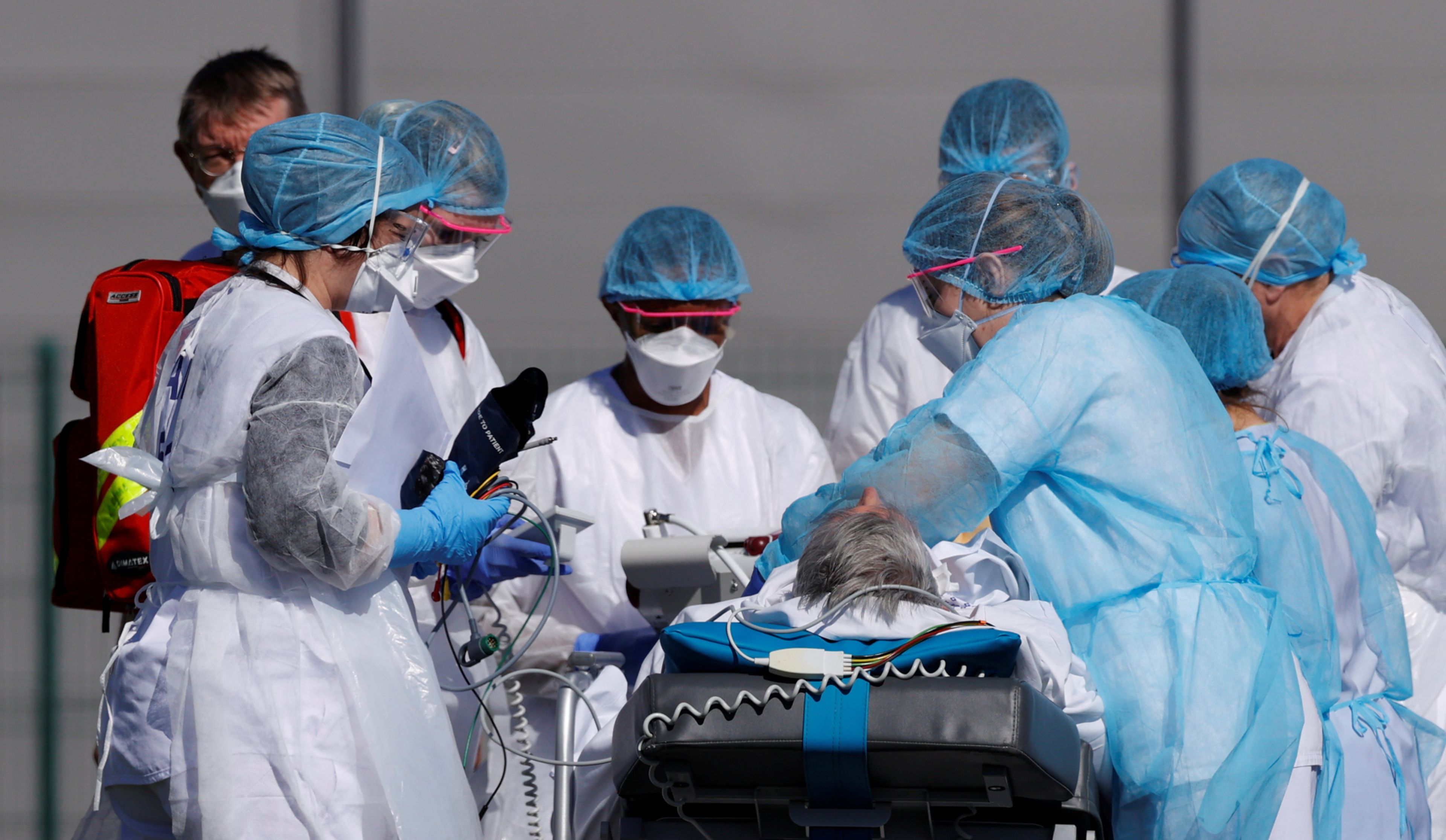 Un equipo médico francés prepara a un paciente con coronavirus para su traslado a Alemania en el aeródromo militar de Mulhouse (Francia)