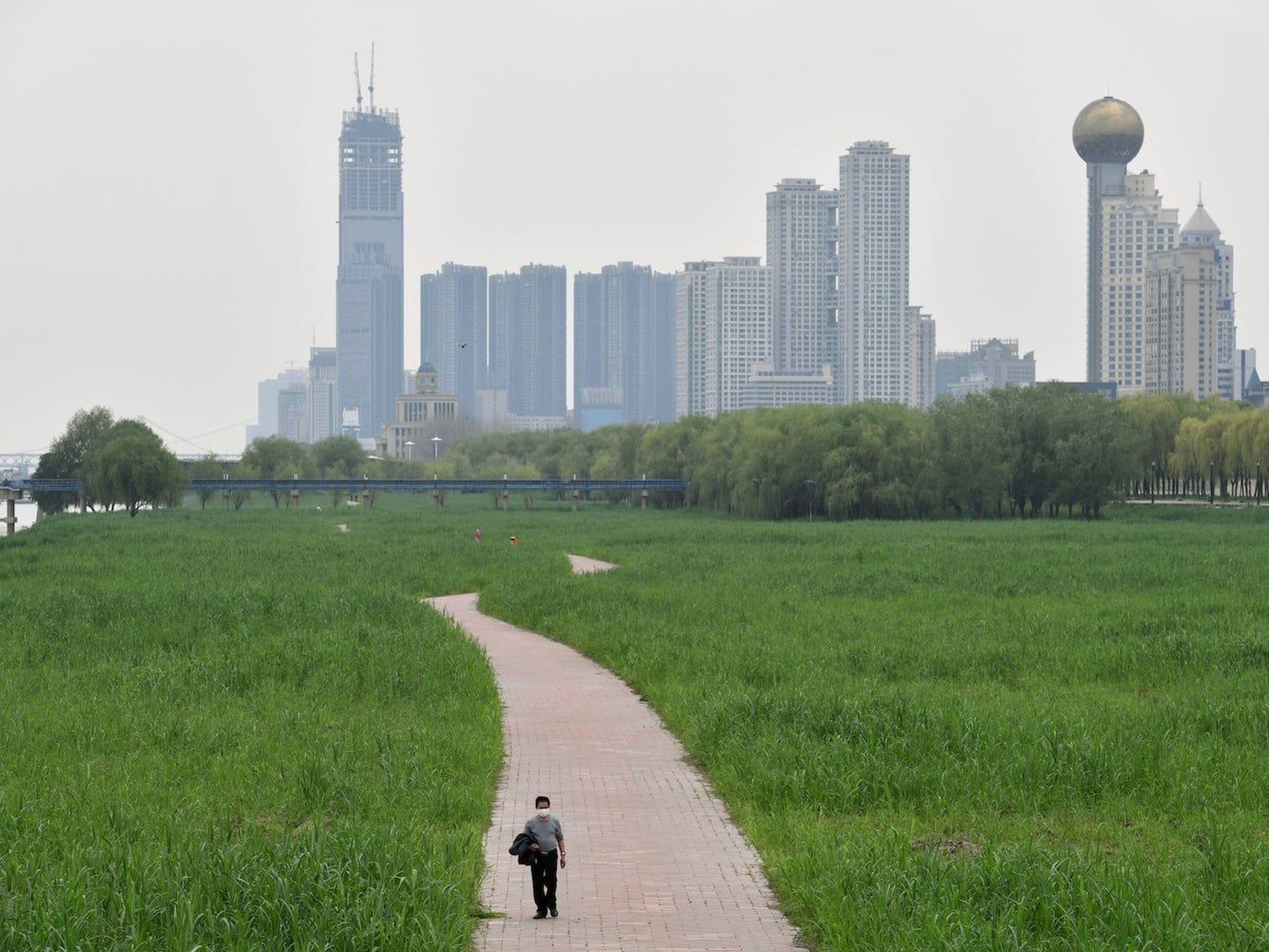 Un hombre camina en un parque junto al río en Wuhan, el 26 de marzo de 2020.
