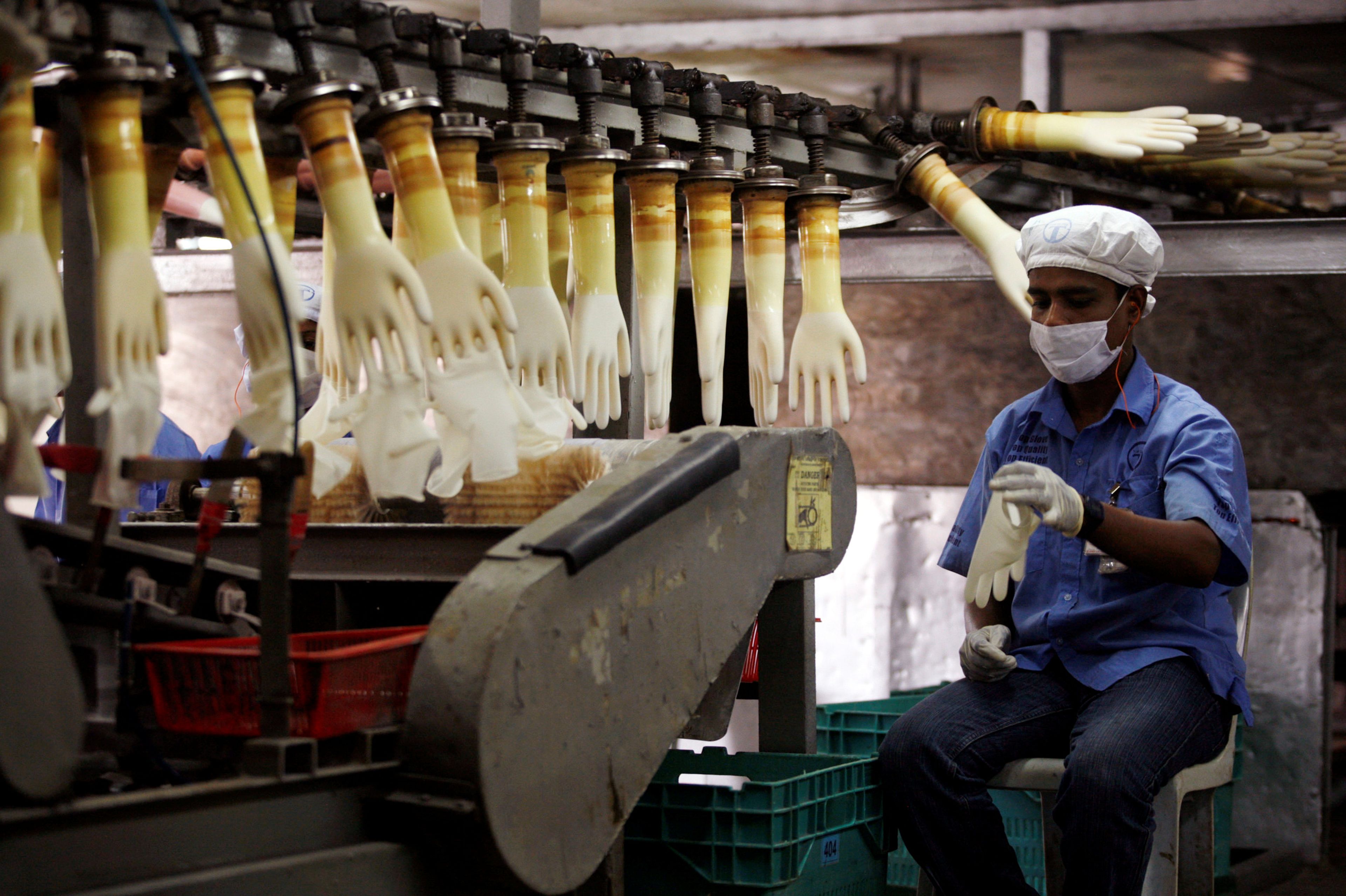 Un trabajador supervisa una línea de producción en una fábrica de Top Glove en Meru, en las afueras de Kuala Lumpur (Malasia), el 25 de junio de 2009.