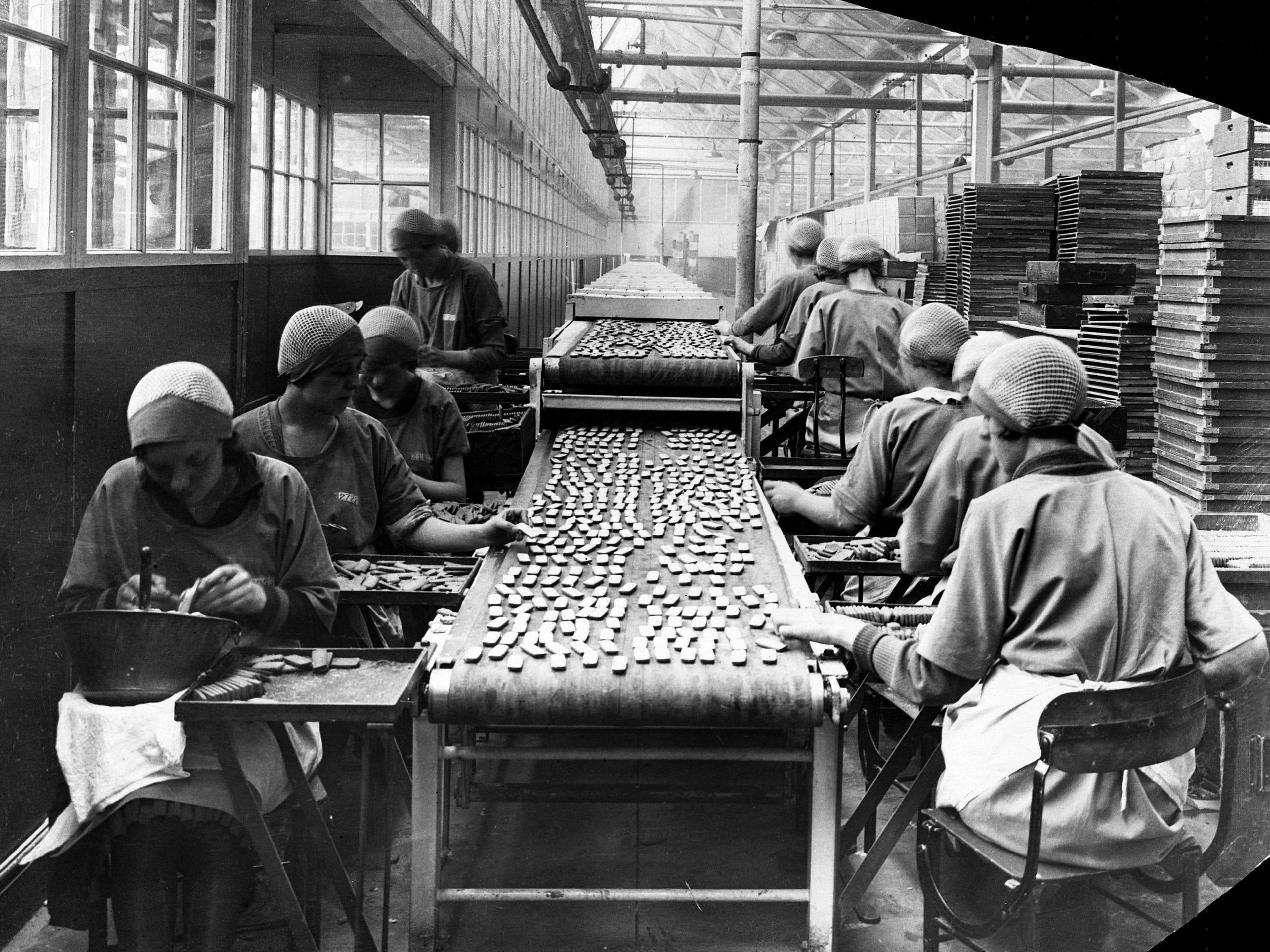 Mujeres glaseando galletas en una fábrica.
