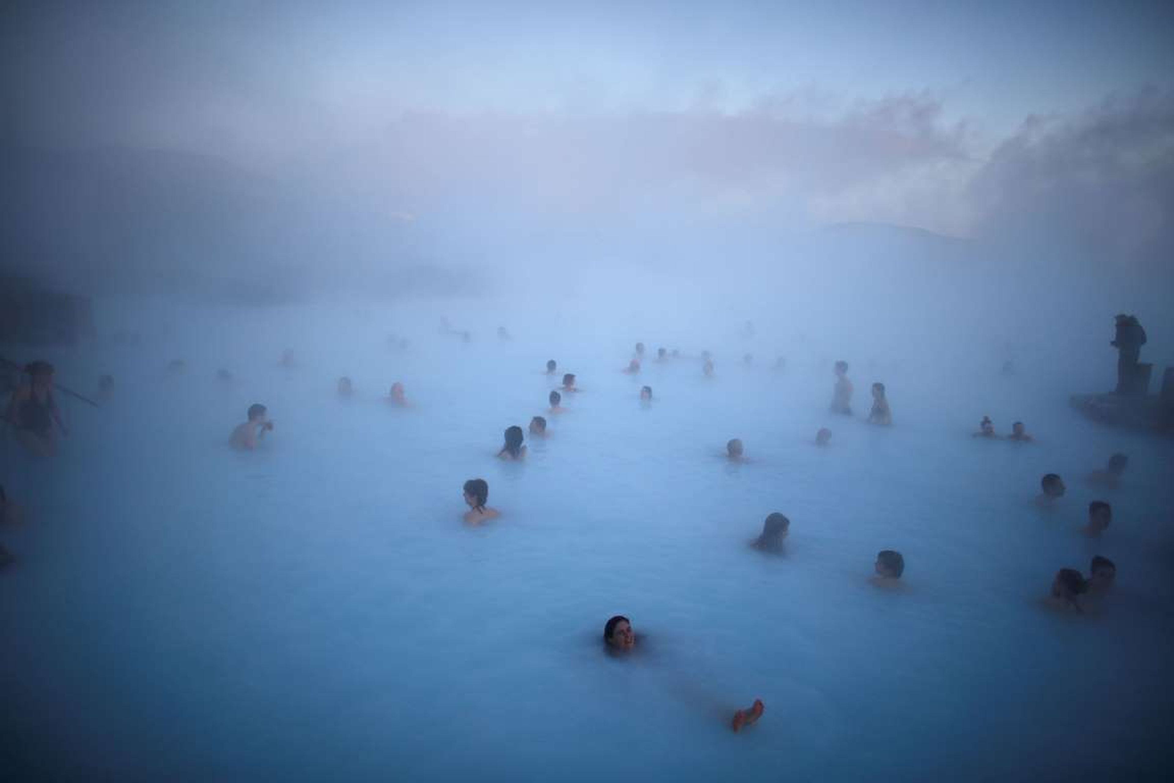 La gente se relaja en una de las fuentes termales de la Laguna Azul, en Islandia.