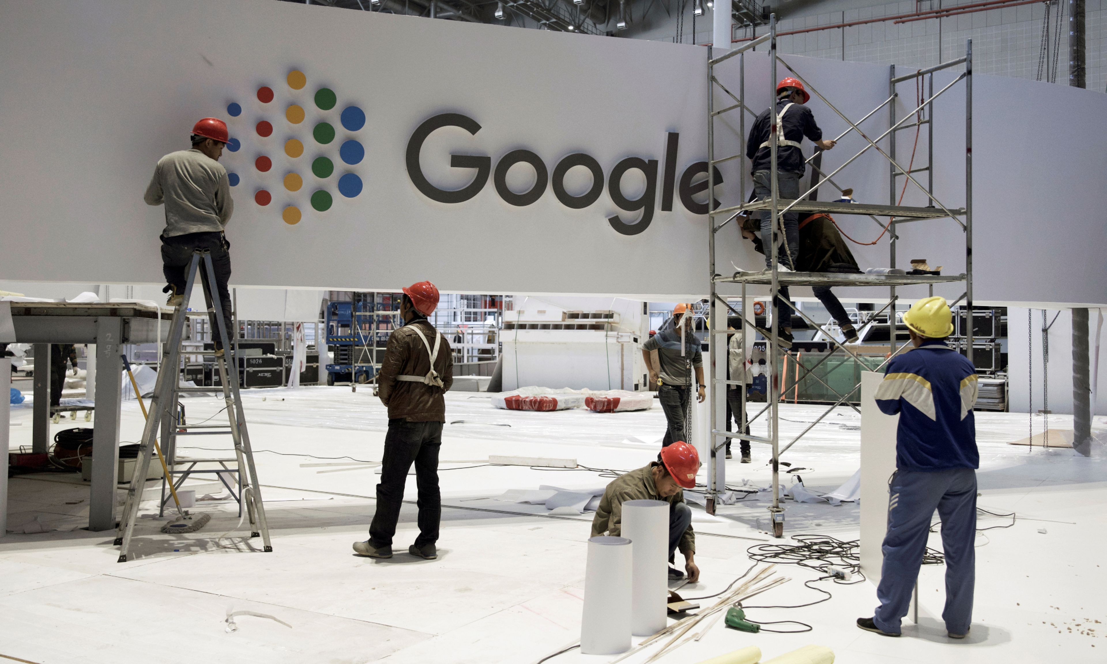 Un grupo de operarios desmonta un stand de Google en la Feria Internacional de Shanghai