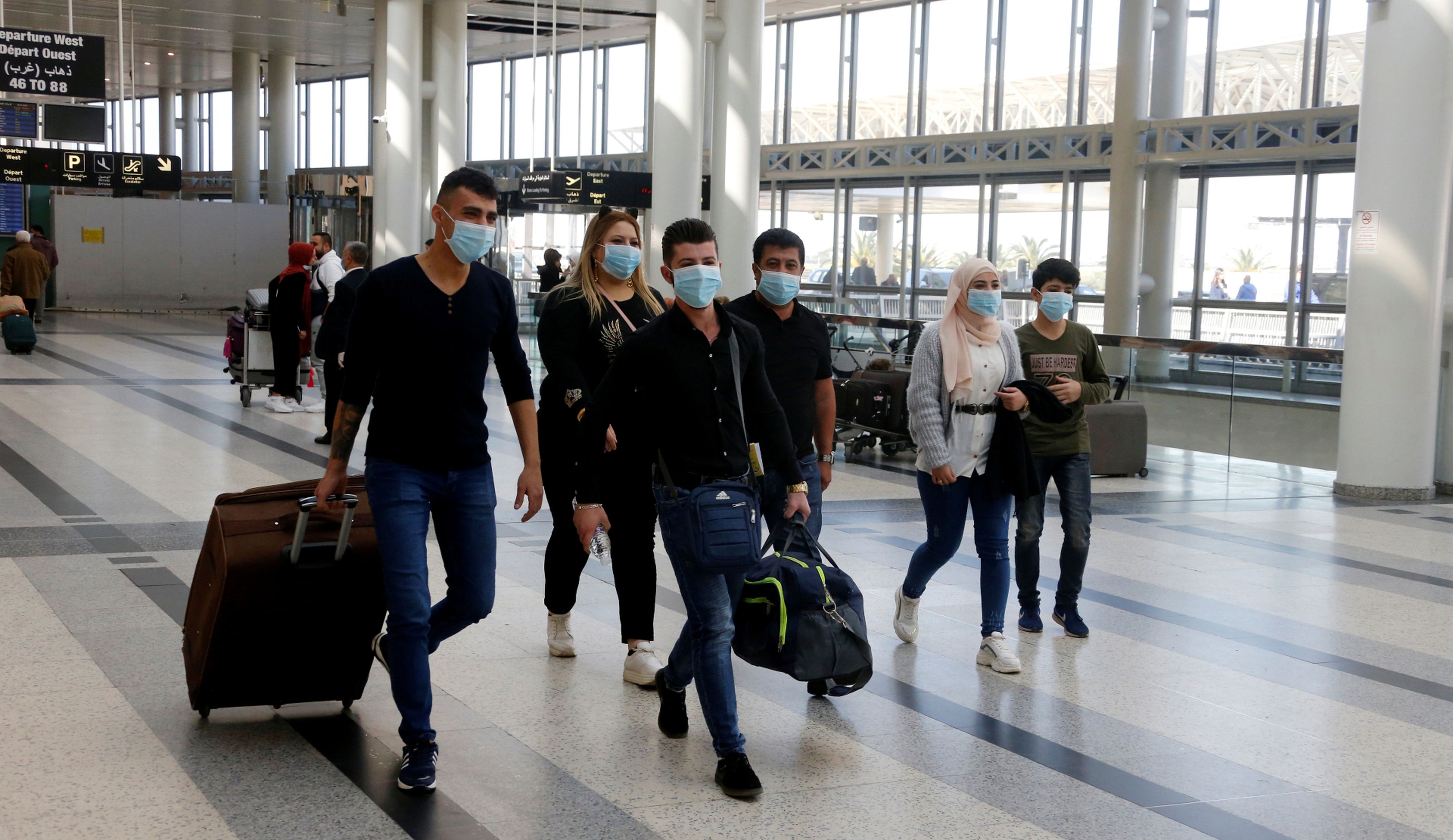Un grupo de pasajeros con mascarilla busca su puerta de embarque en el aeropuerto de Beirut