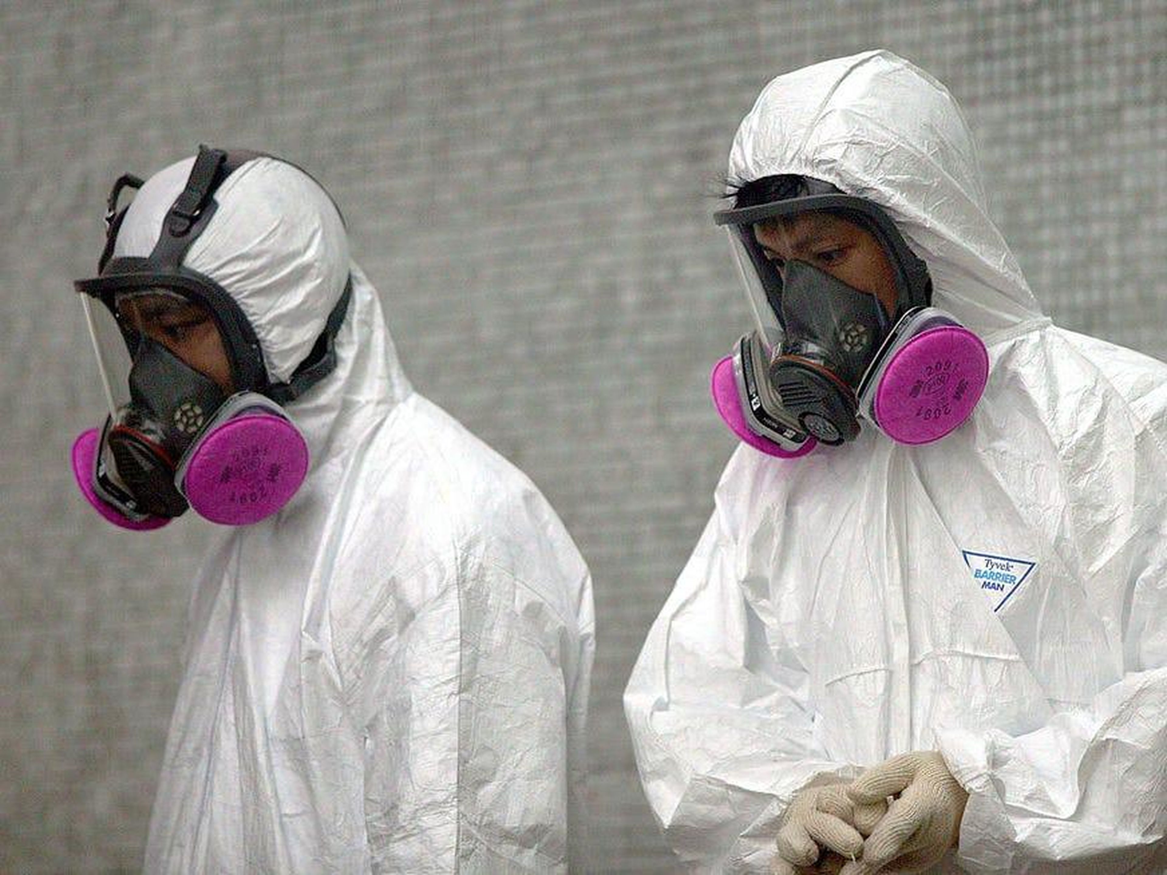 Trabajadores de la salud usan ropa protectora completa durante una operación de limpieza en Amoy Gardens en Hong Kong, donde más de 200 residentes fueron infectados con SARS, el 4 de abril de 2003.
