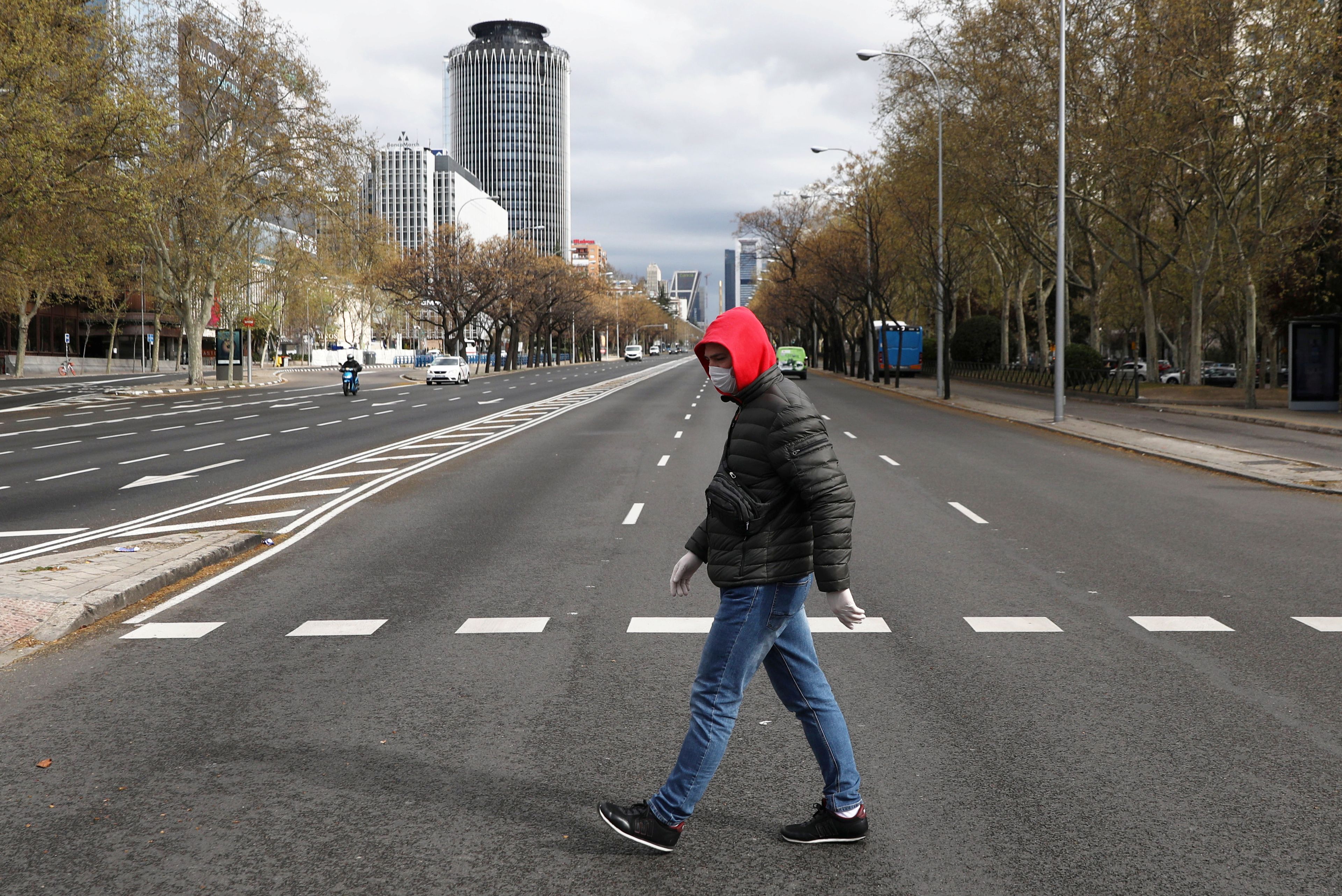 Un hombre cruza el Paseo de la Castellana en Madrid medio de la crisis del coronavirus.