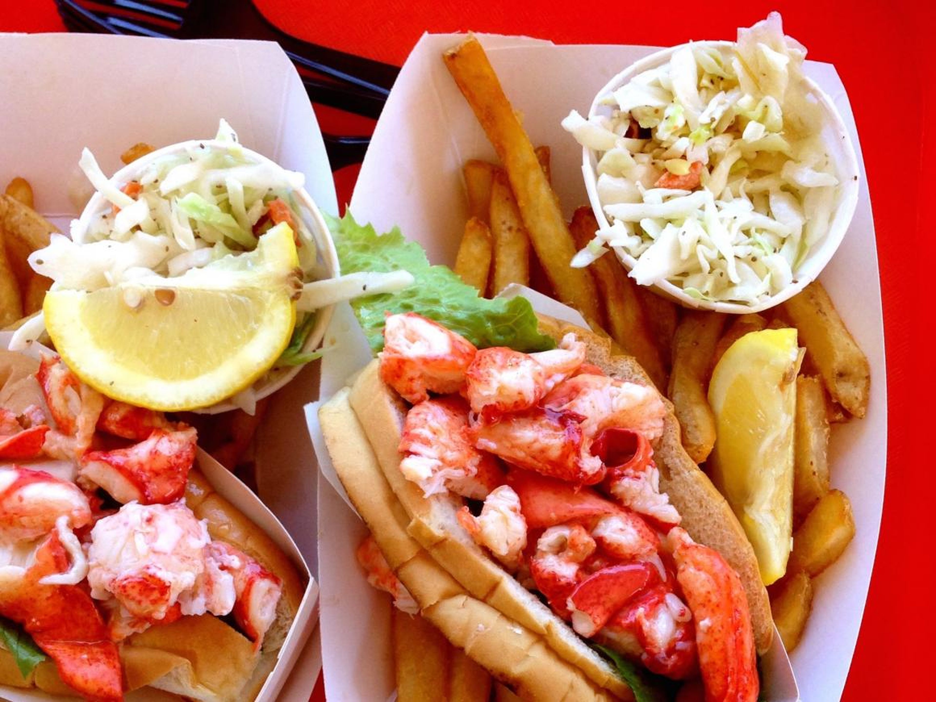 Lobster rolls con ensalada de col y papas fritas.