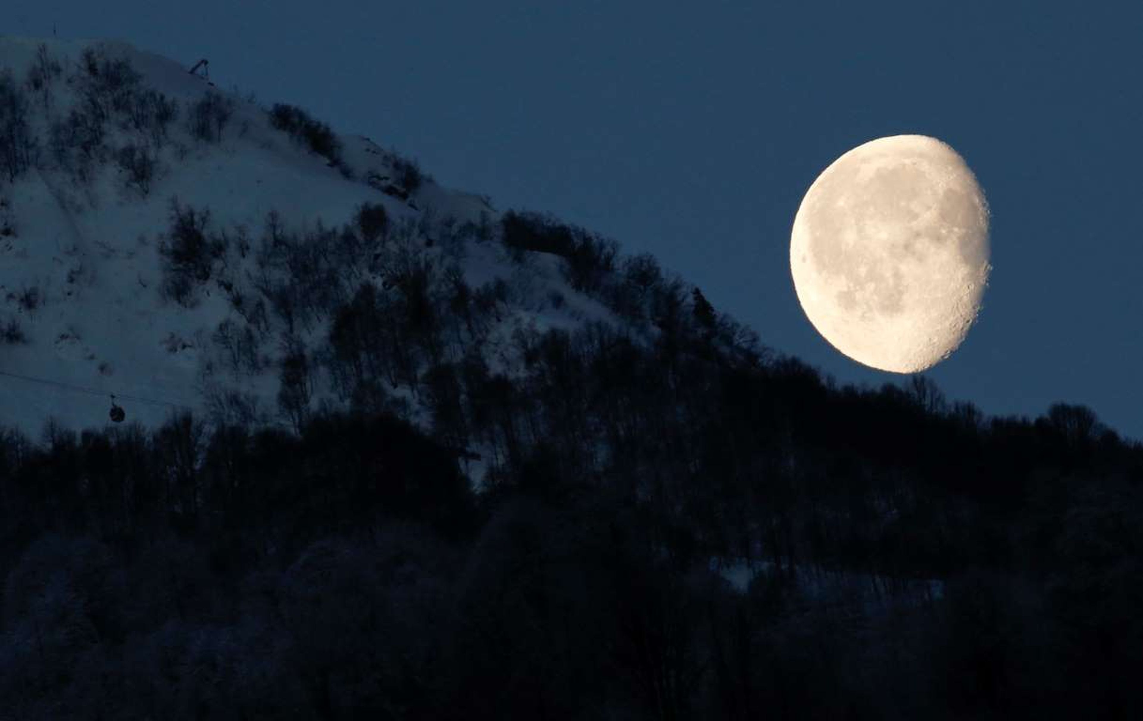 La luna se asoma por encima de las montañas en Rosa Khutor, Rusia, durante los Juegos Olímpicos de Sochi 2014.