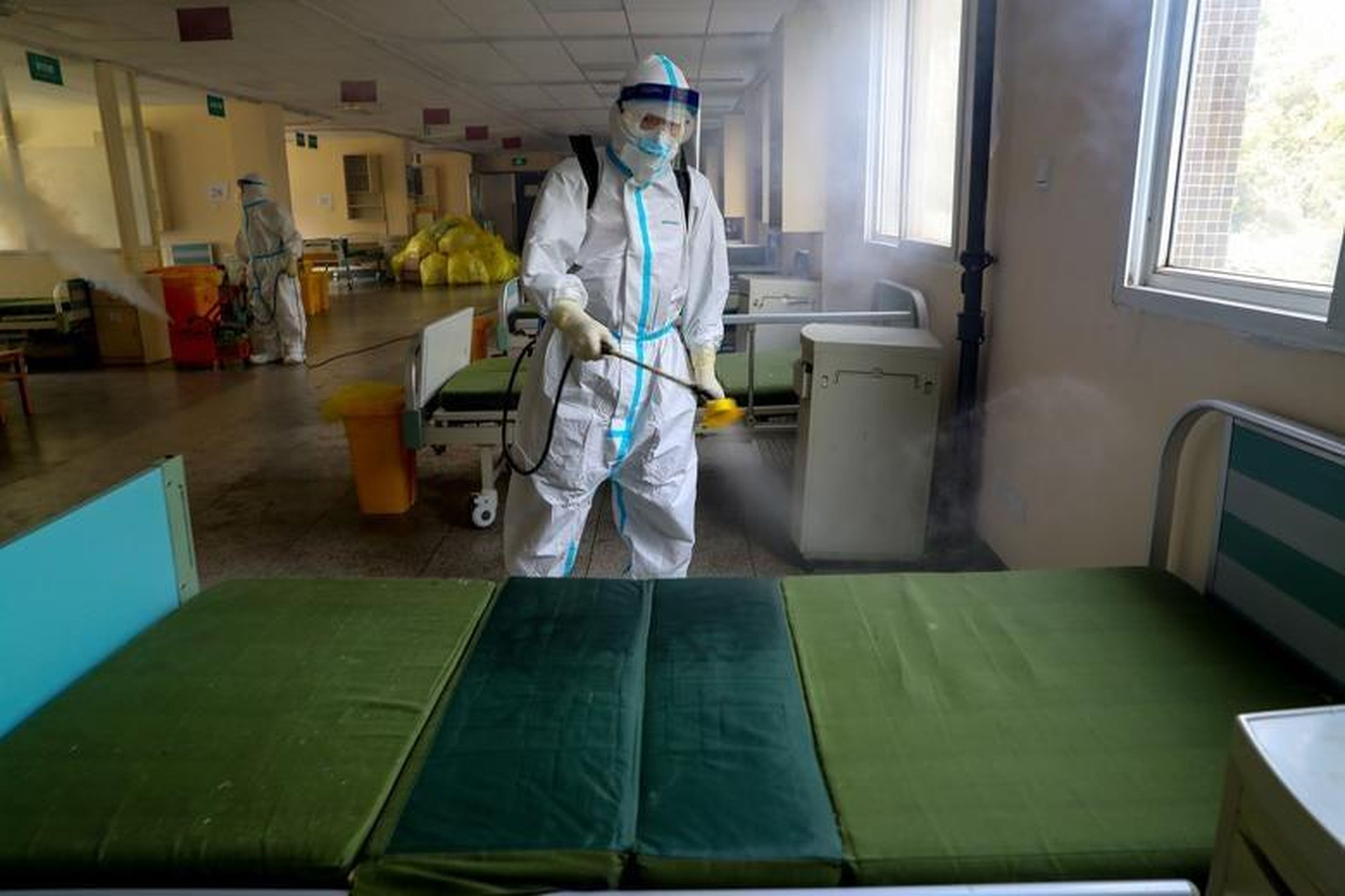 Un trabajador con un traje de protección desinfecta el Hospital Wuhan número 7, que fue designado para atender a pacientes con la Covid-19, el 19 de marzo de 2020.
