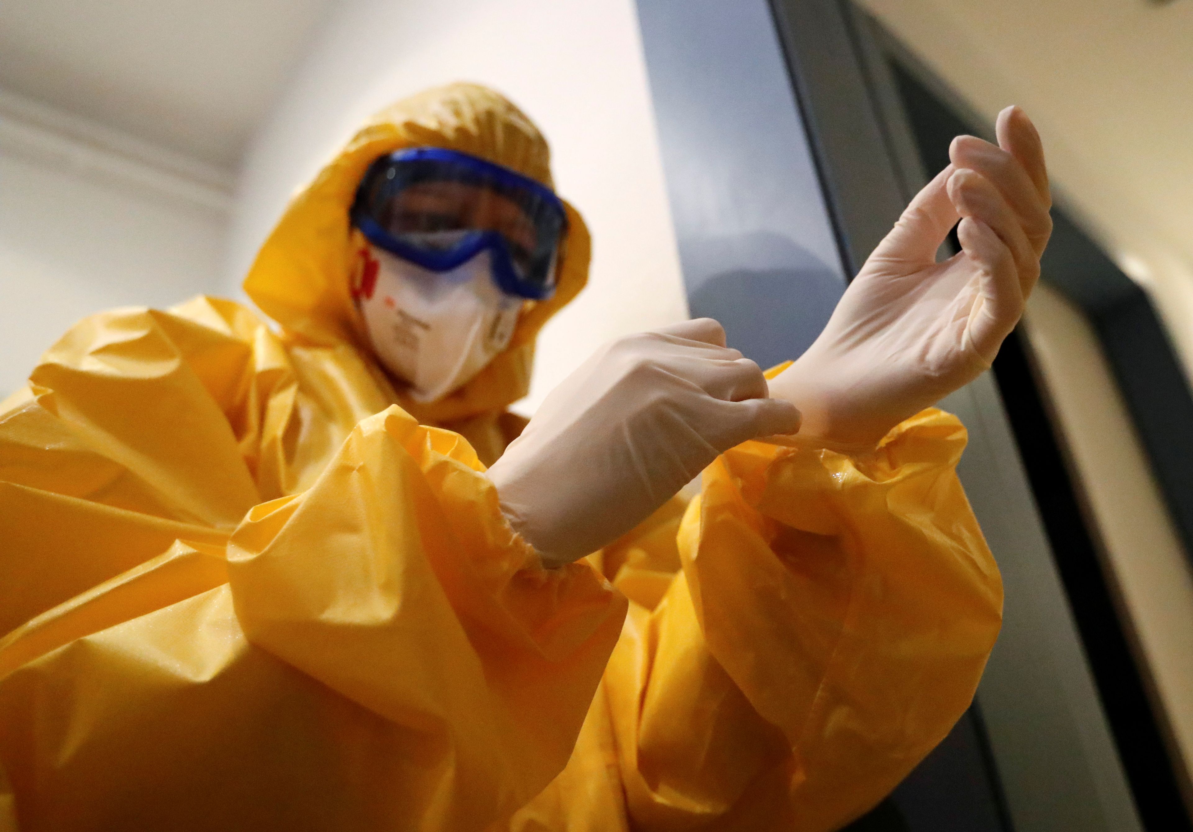 Un médico se equipa con un traje protector en medio de la pandemia del coronavirus