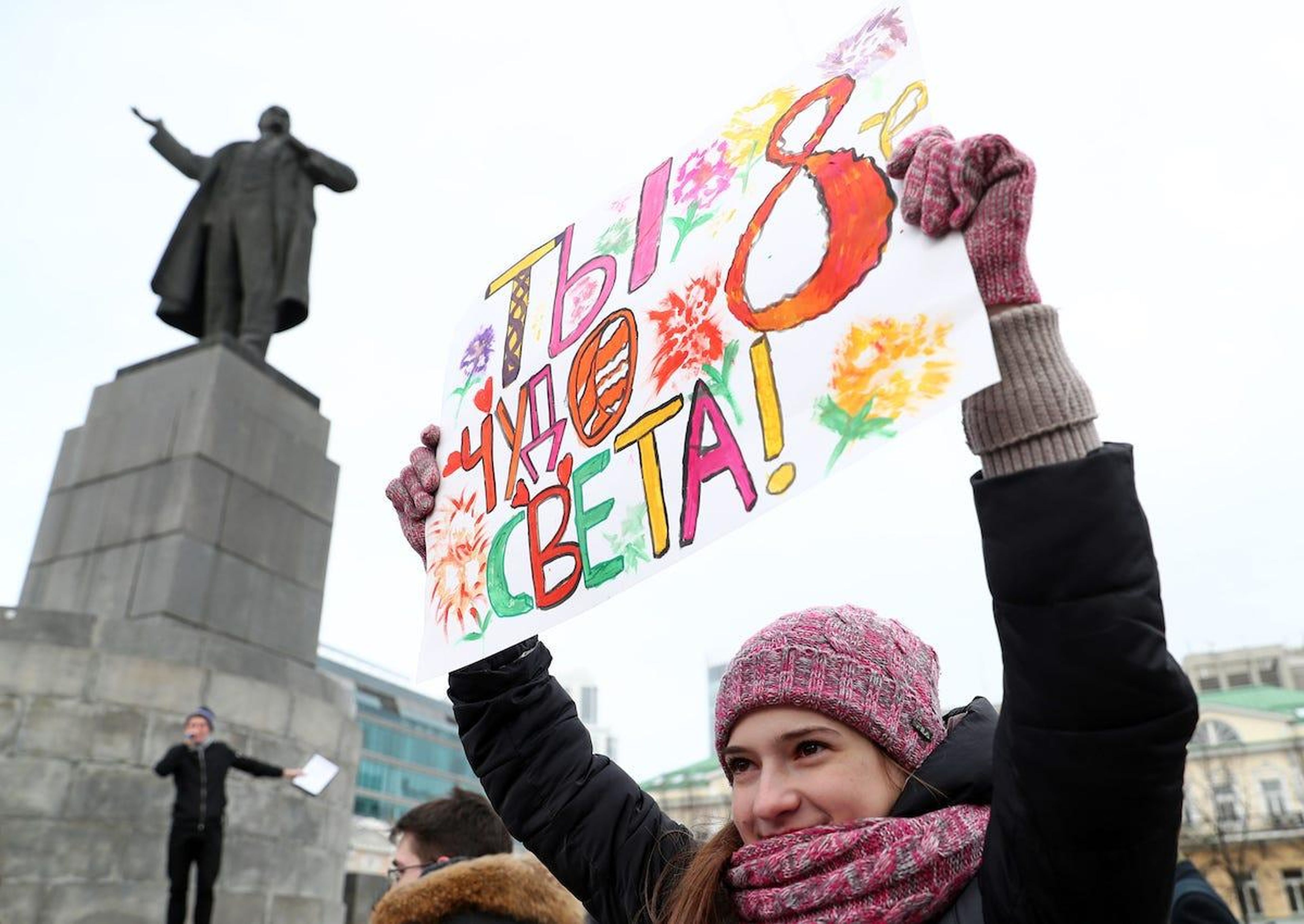 A member of the United Russia Young Guard holds a placard reading "You're the World's 8th Wonder" during a march to mark International Women's Day.