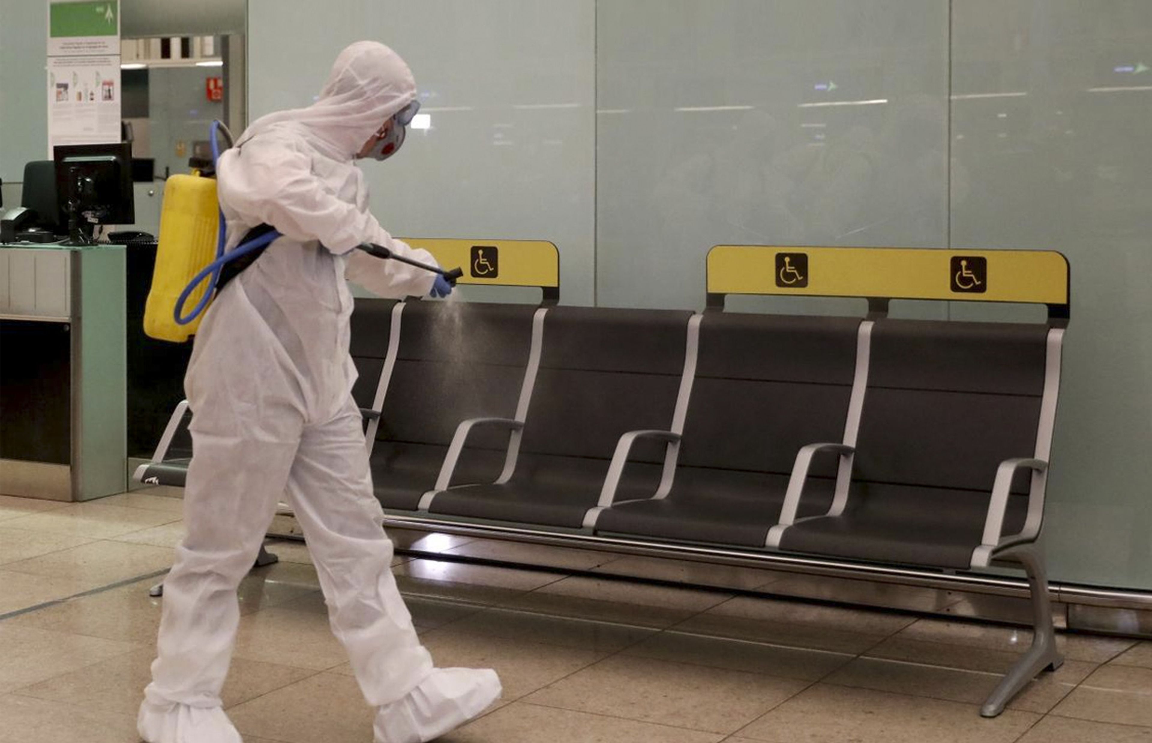 Un miembro de la UME limpia de coronavirus el aeropuerto de El Prat.