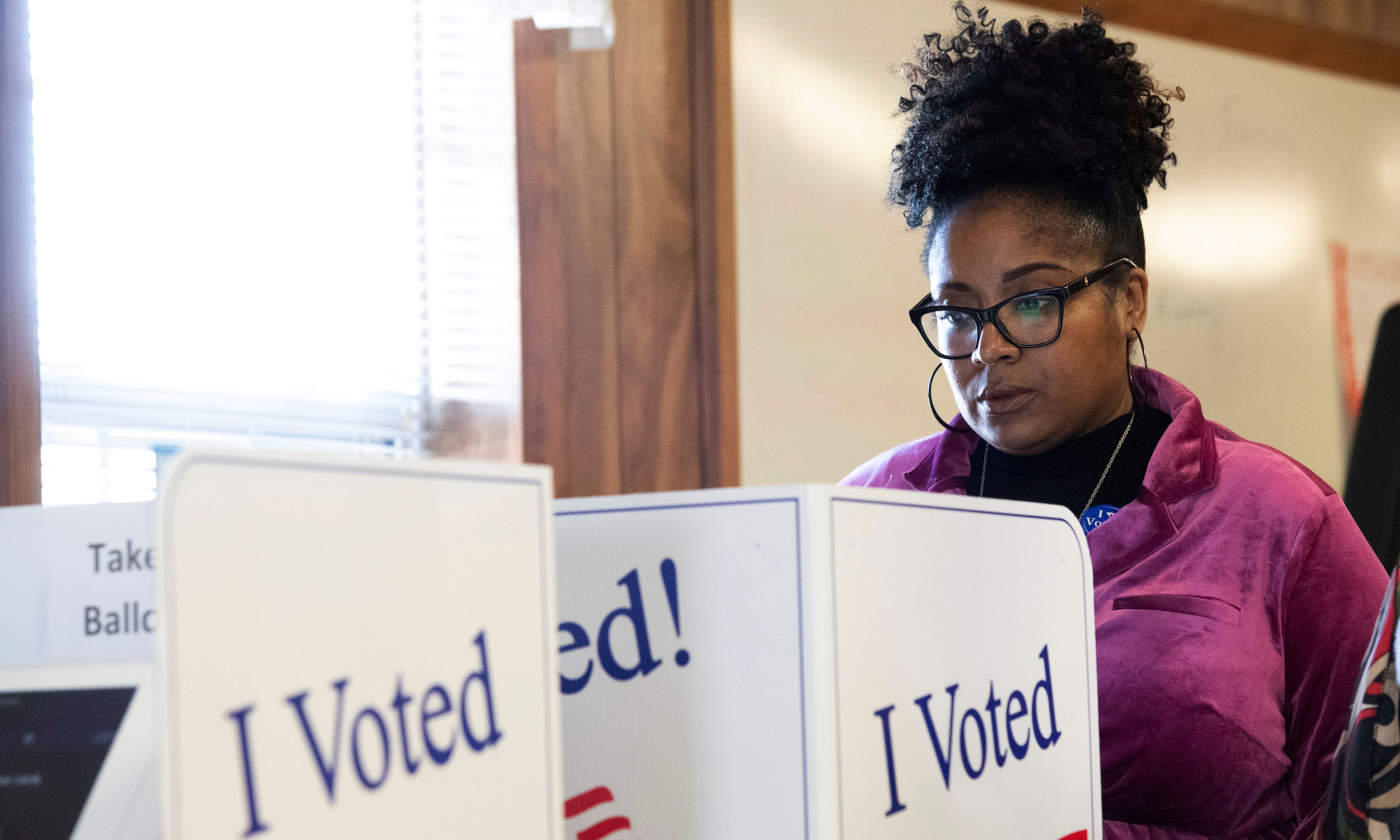 Una mujer deposita su voto en las cabinas electorales de las primarias demócratas en Carolina del Sur