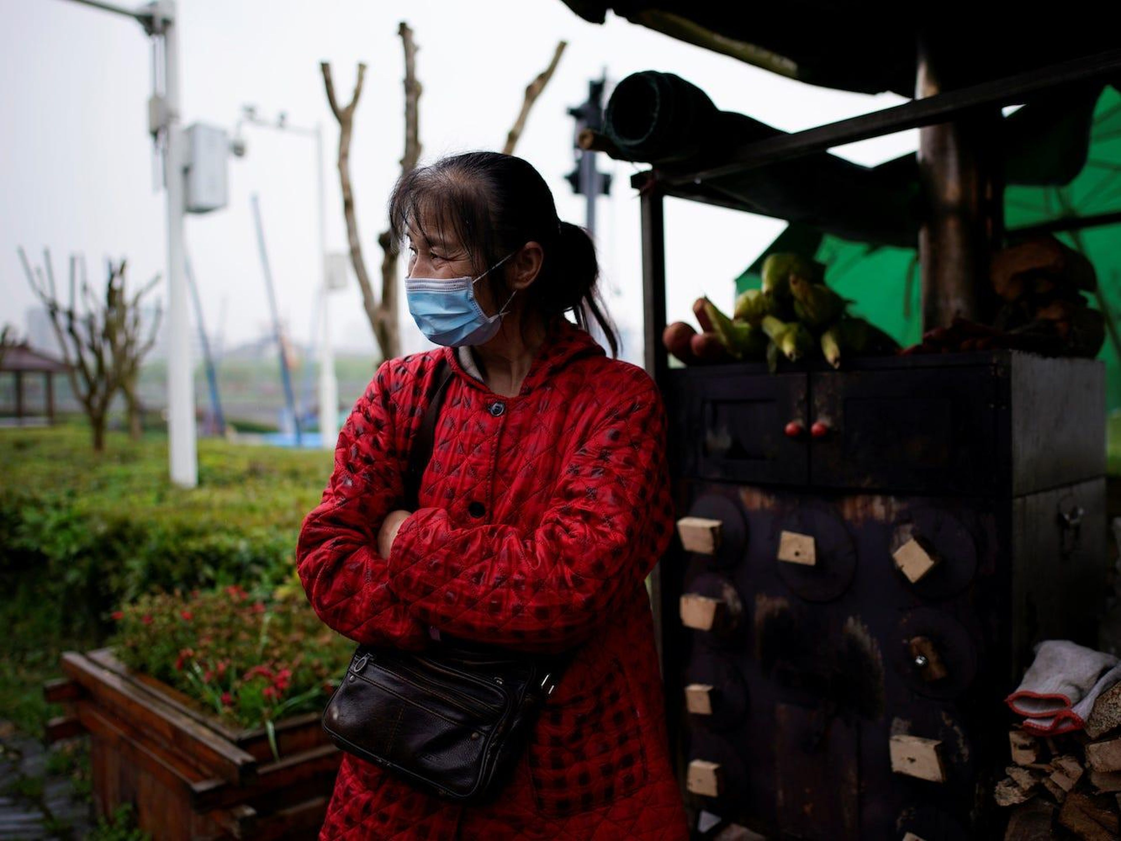 Li Yu, de 55 años, vendedora de maíz, usa una mascarilla en la antigua muralla de la ciudad de Jingzhou después de su reapertura el 26 de marzo de 2020.