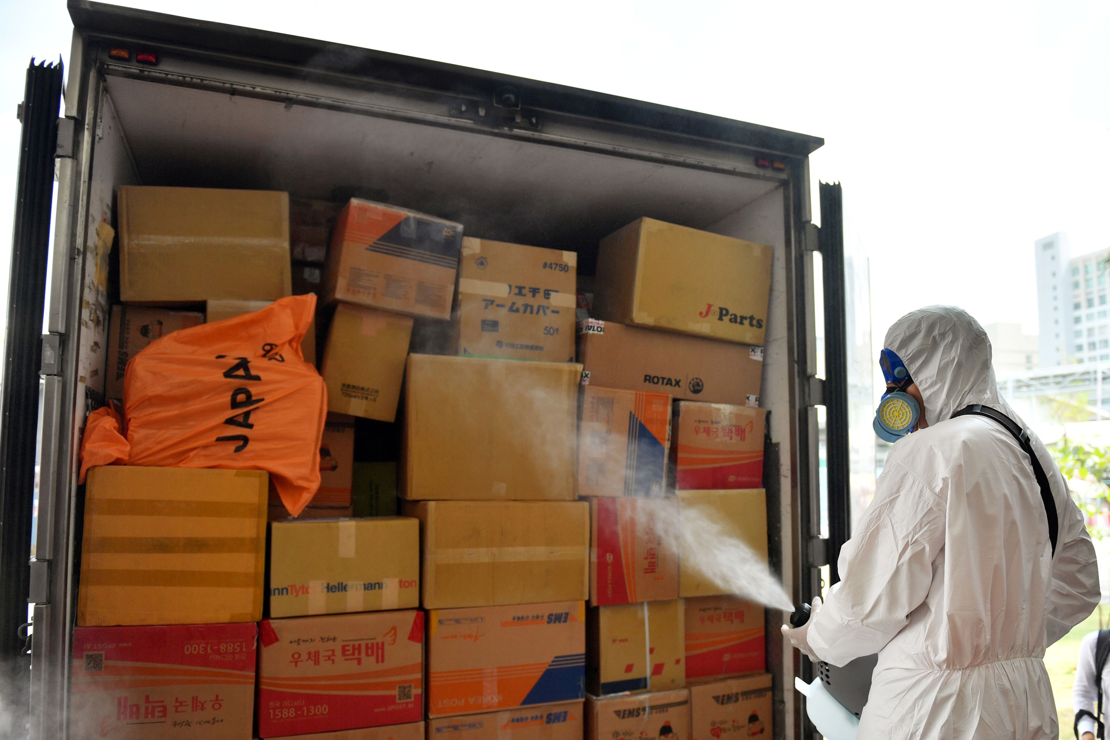 Un operario desinfecta un camión de transporte por el brote del coronavirus