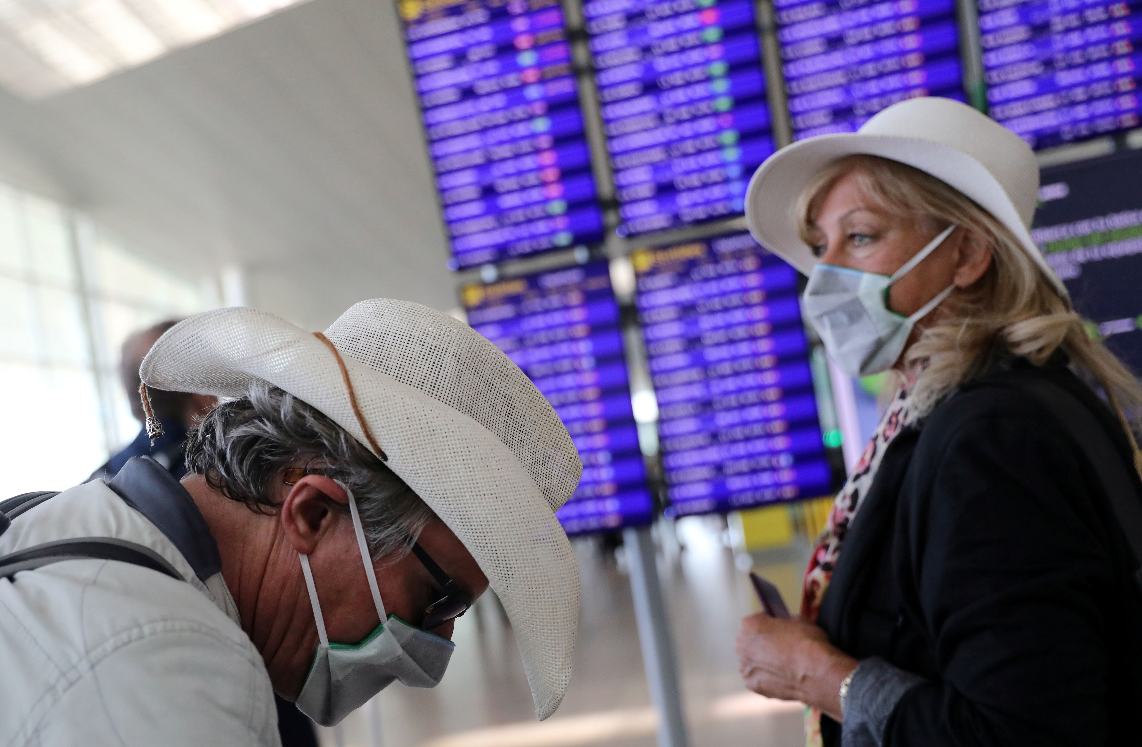 Una pareja de turistas se cubren con mascarillas por la crisis del coronavirus.
