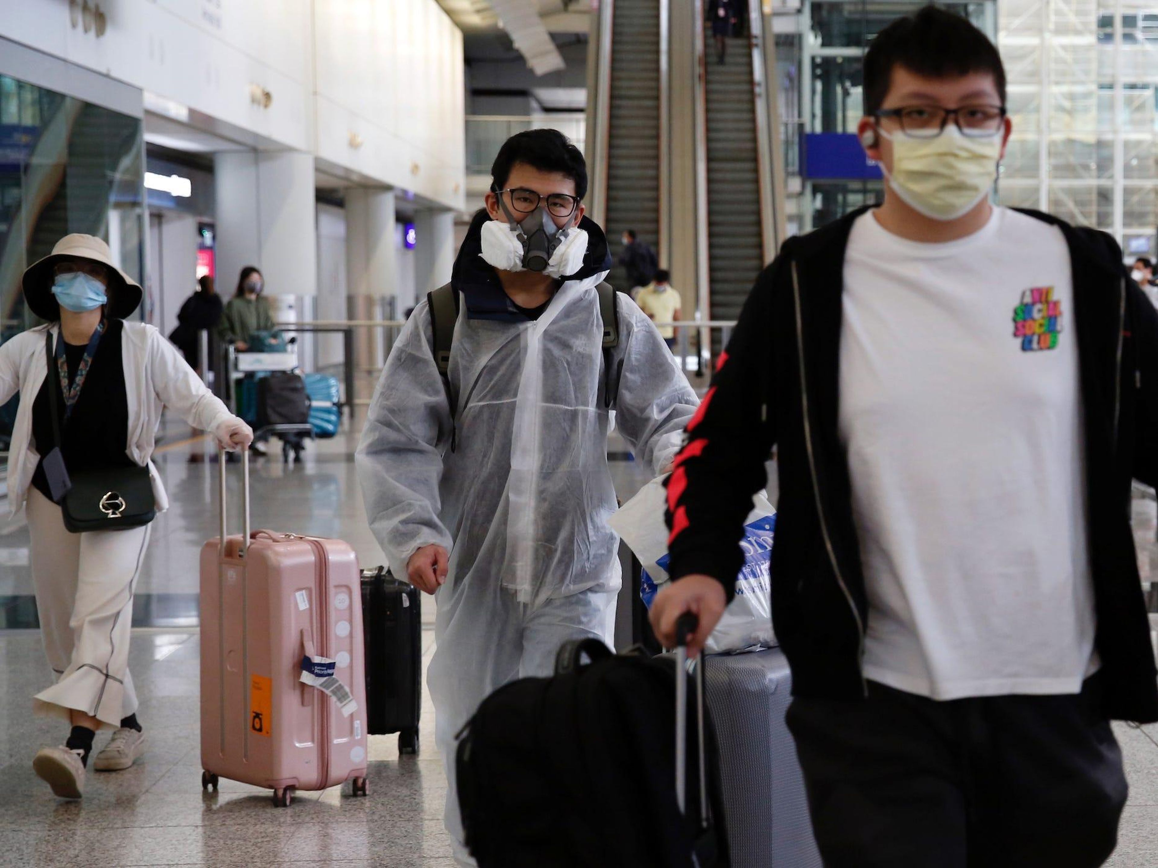 Un pasajero que regresa de Londres lleva un traje protector en el aeropuerto internacional de Hong Kong, el 17 de marzo de 2020.