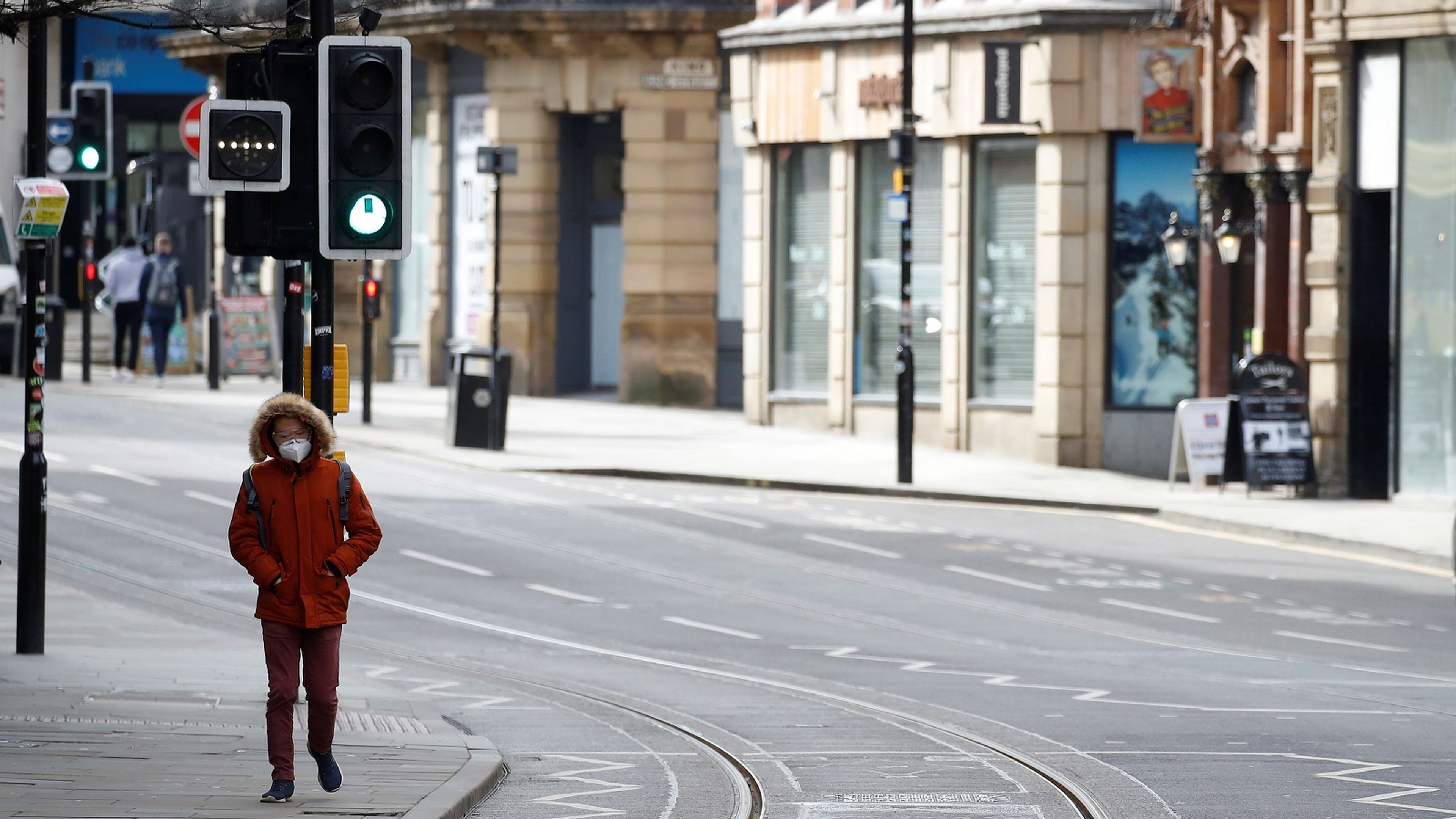 Una persona camina por una calle desierta de Manchester (Reino Unido) durante el brote de coronavirus.