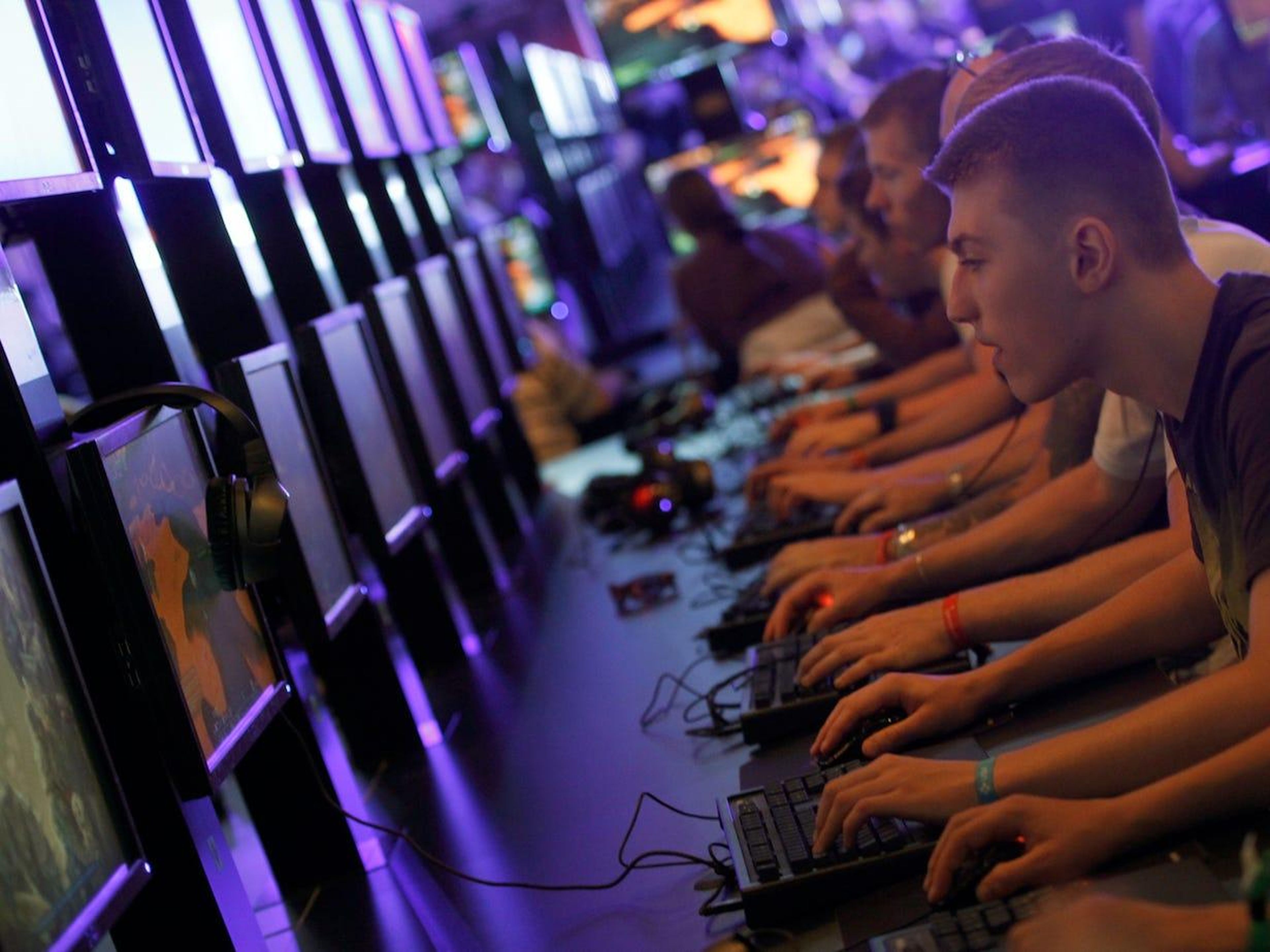Visitantes de la convención Gamescom, la feria de videojuegos más grande de Europa, probando nuevos juegos.