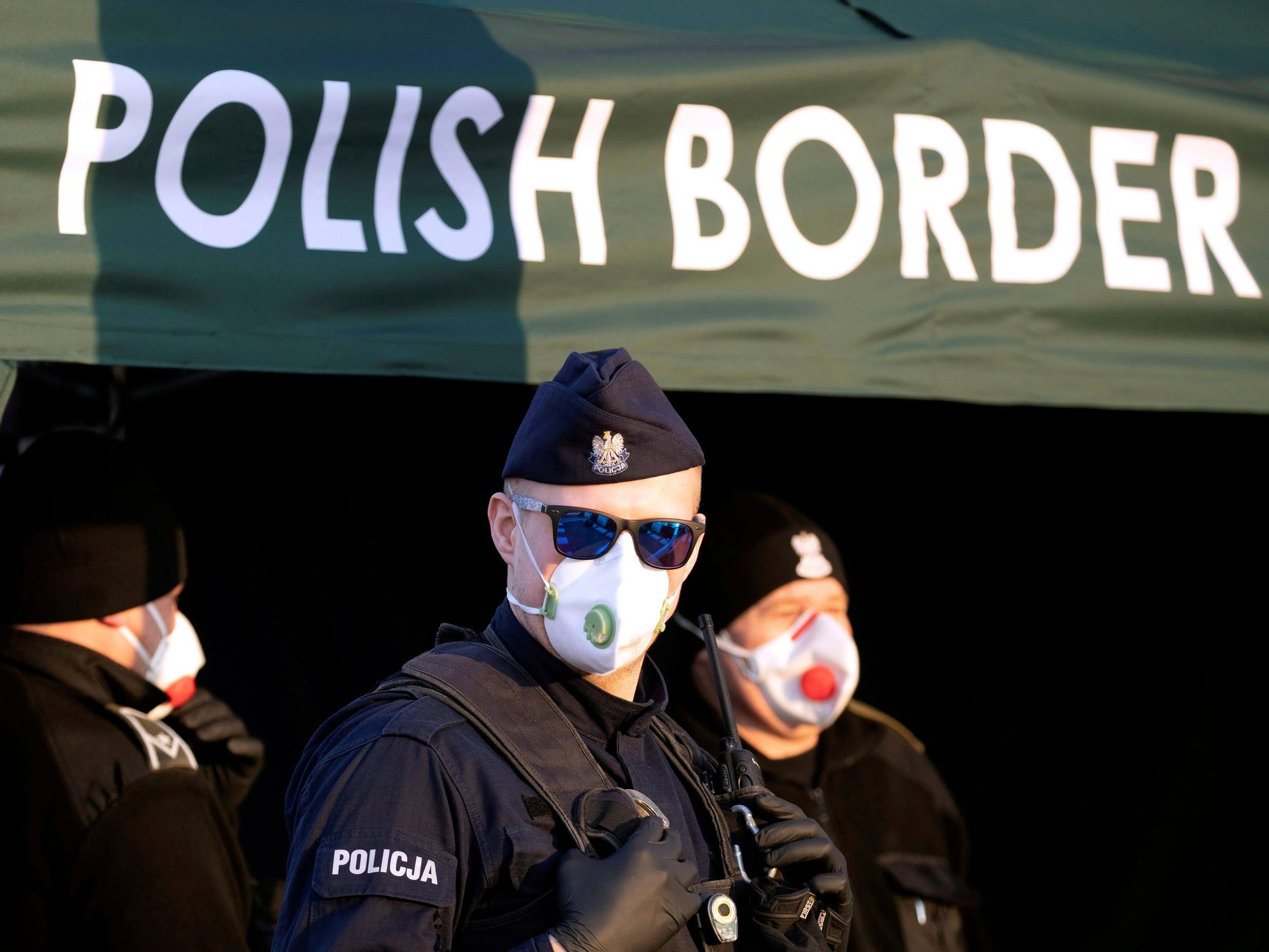 A Polish police officer, wearing a protective mask, stands at the border between Germany and Poland on March 23, during coronavirus disease symptoms testing for people returning to Poland.