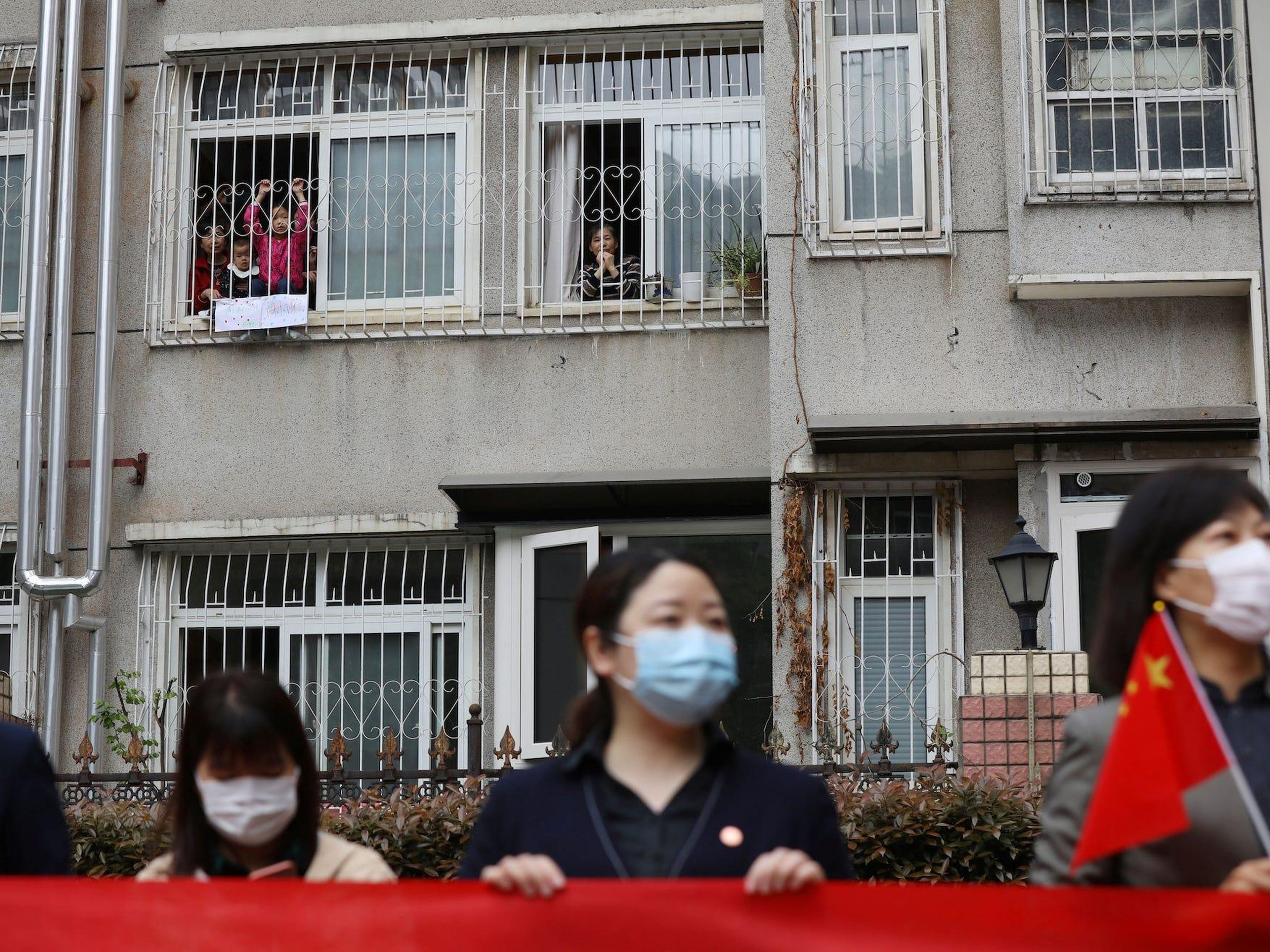 Los residentes despiden desde sus casas a un equipo médico de la provincia de Guizhou que sale de Wuhan, China, el 25 de marzo de 2020.