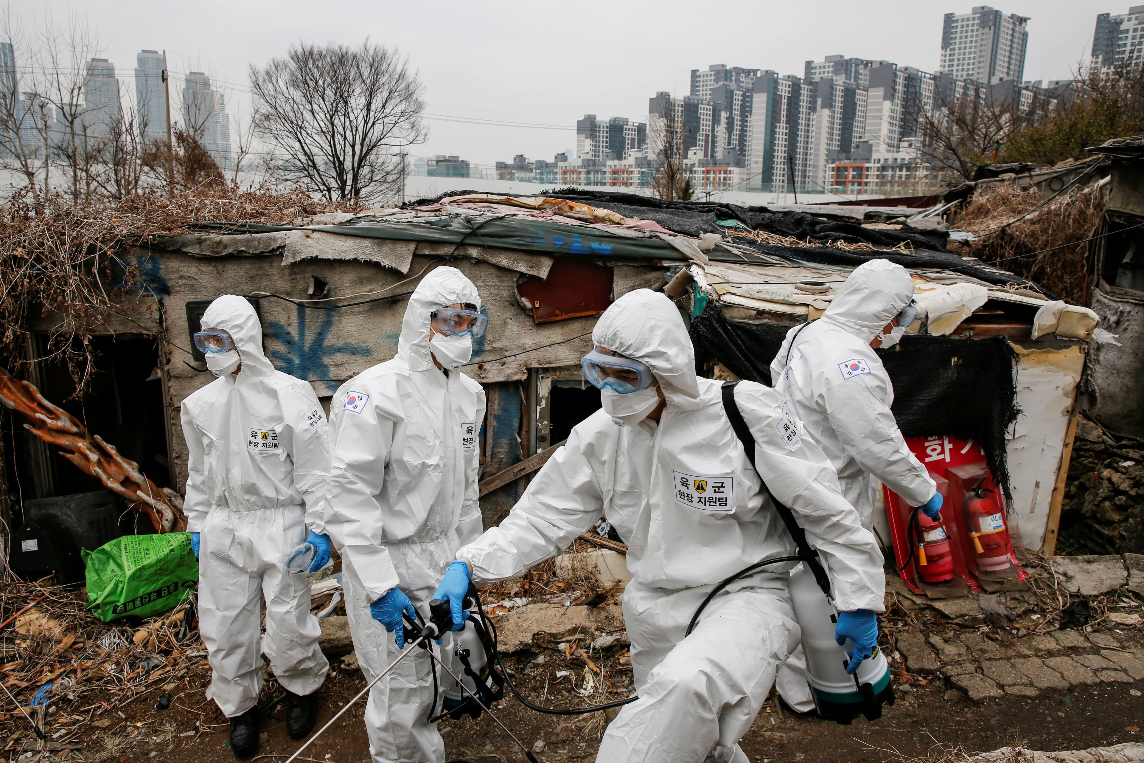 Soldados surcoreanos desinfectando los barrios pobres de Corea del Sur.