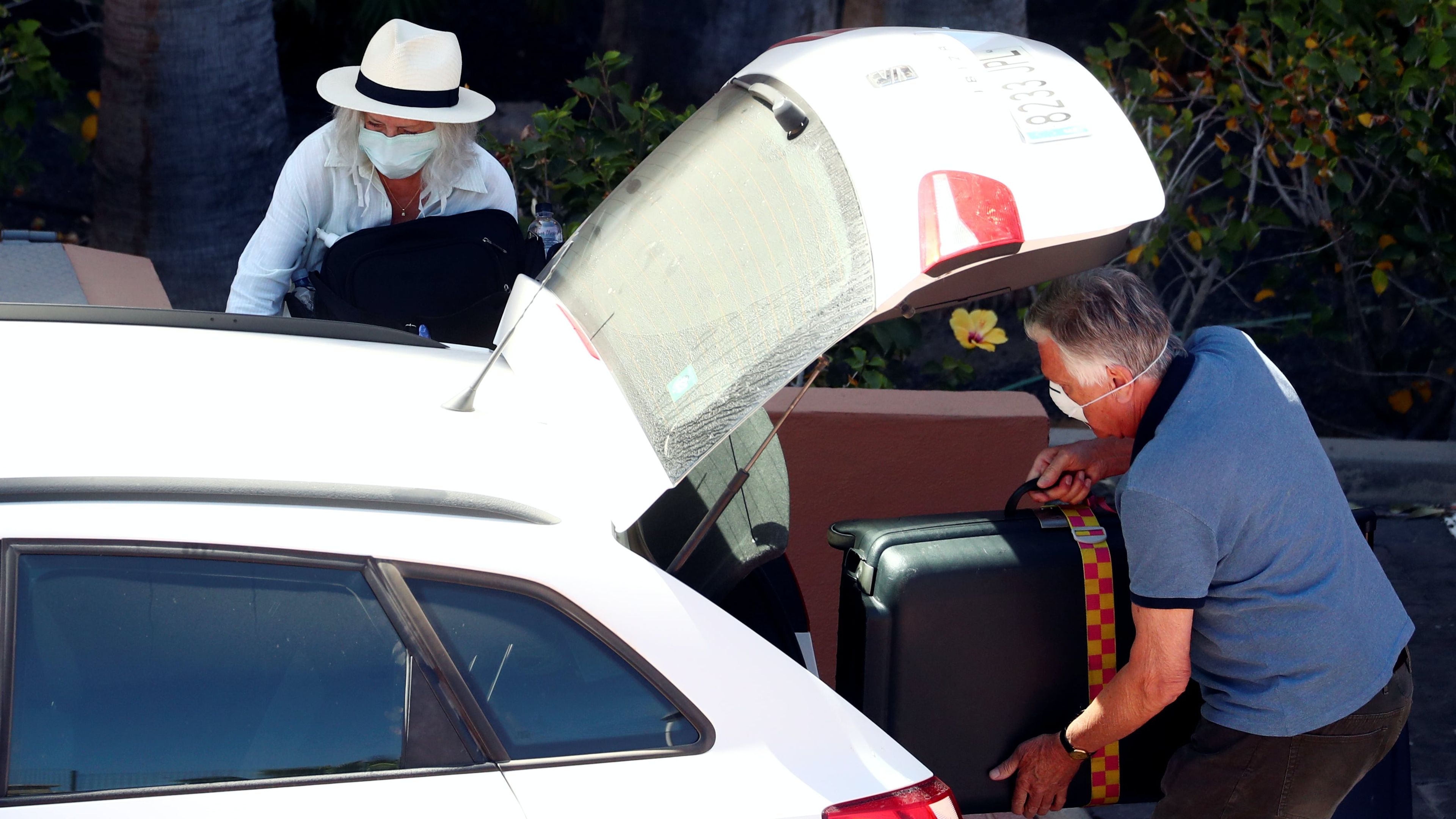 Un taxista recoge a unos clientes con mascarilla por el coronavirus.