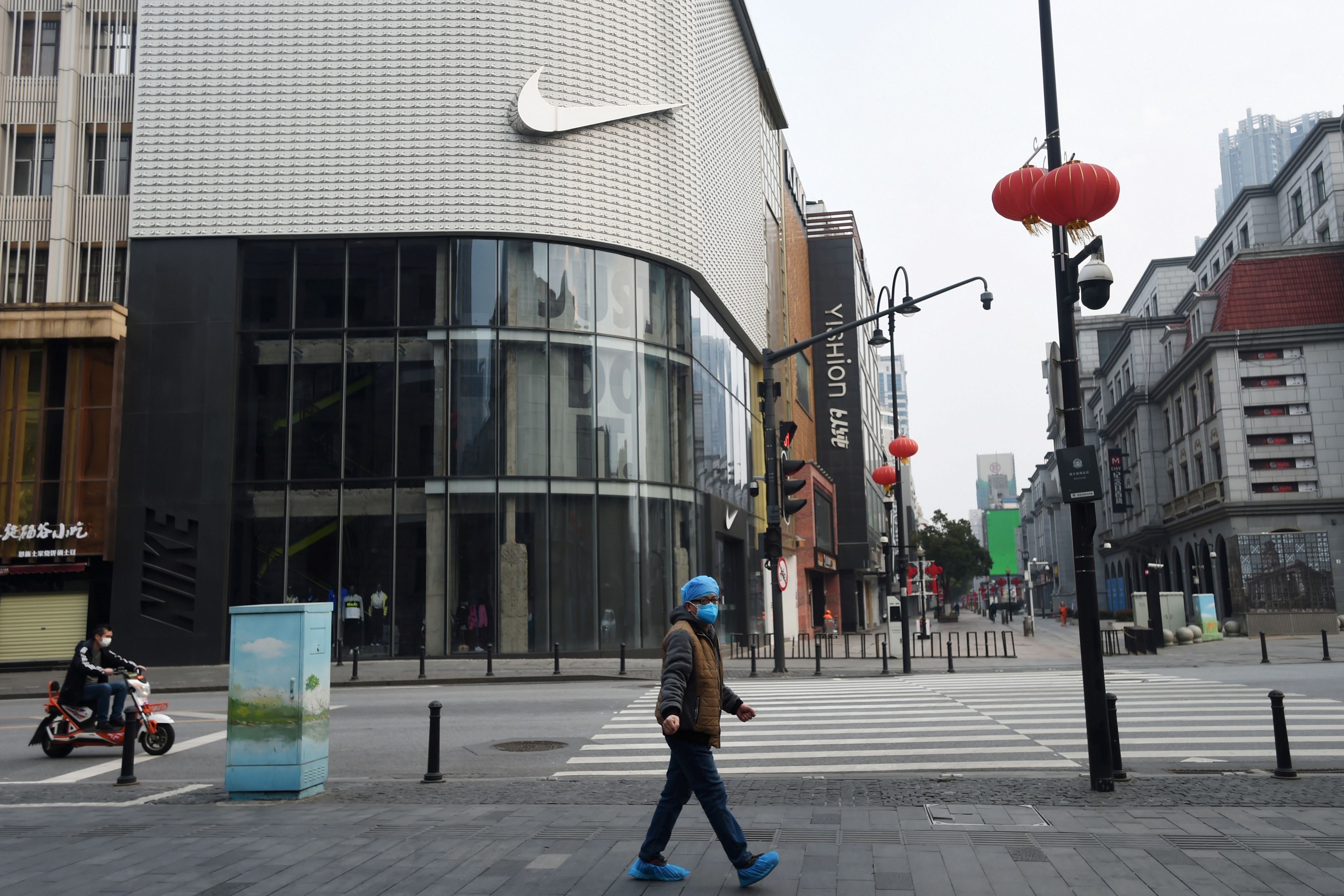 Un hombre pasea delante de una tienda de Nike cerrada durante la crisis de coronavirus