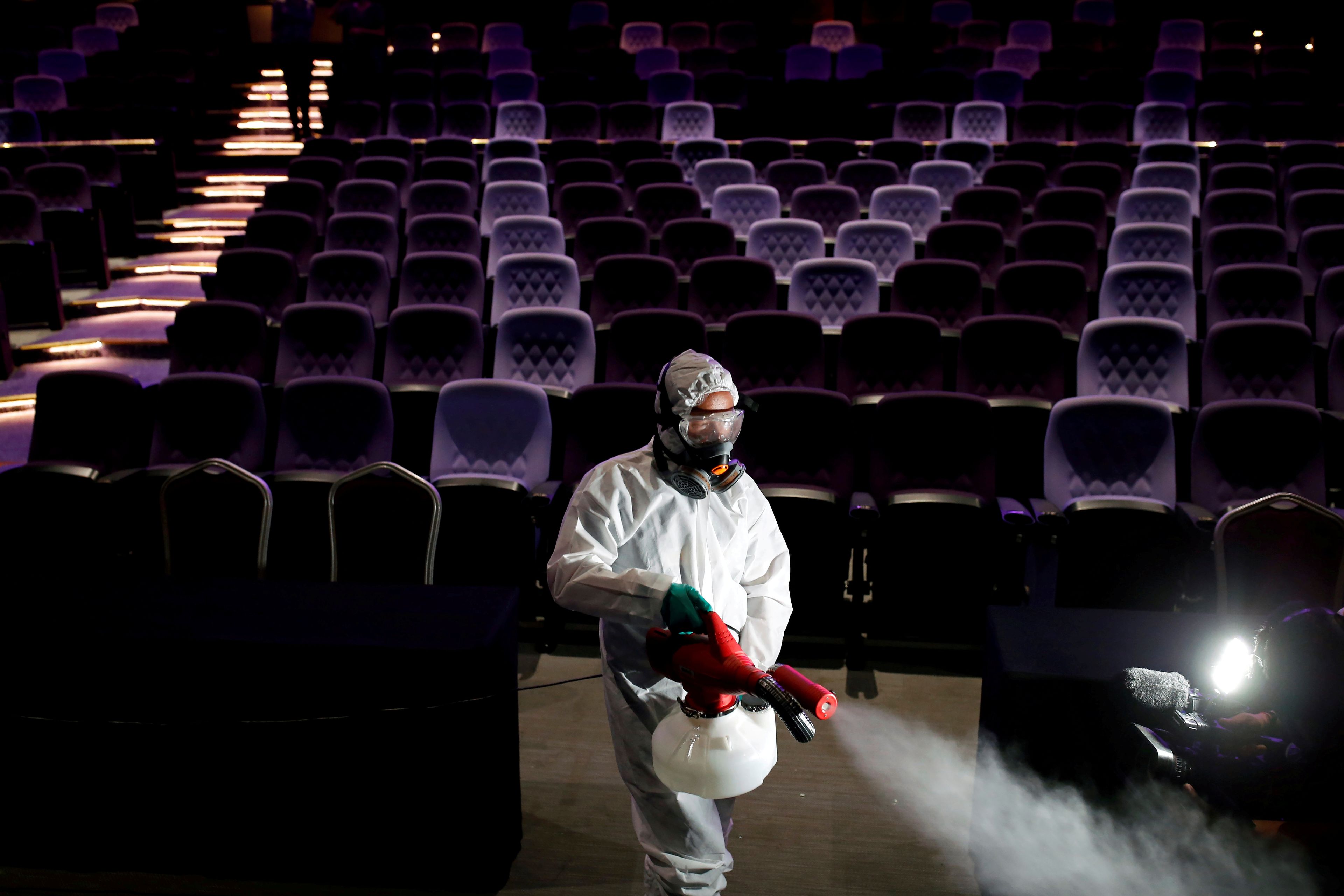 Un trabajador con traje protector desinfecta un teatro en Tailandia en medio del brote del coronavirus