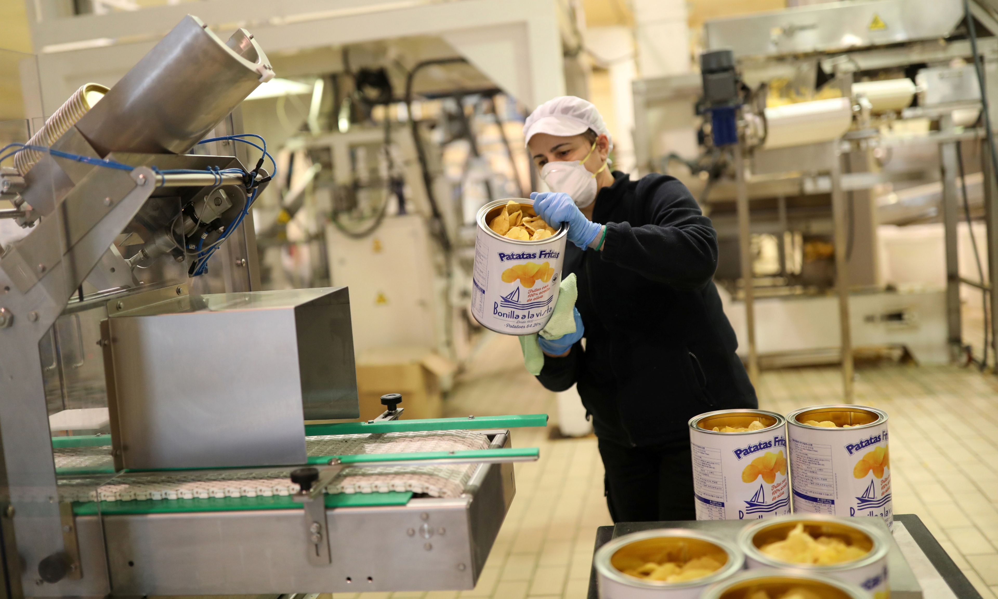 Una trabajadora de Bonilla a la Vista limpia una lata de patatas fritas en la fábrica de la empresa en Arteixo (A Coruña)