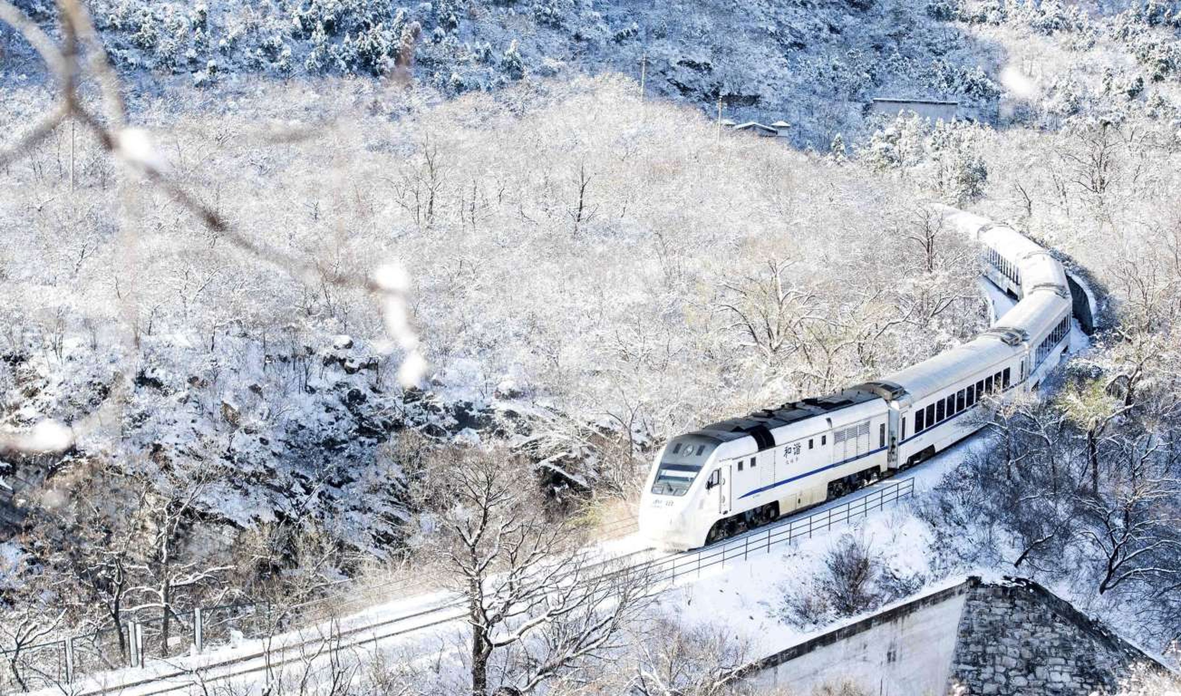 Un tren viaja a través de colinas cubiertas de nieve en las afueras de Beijing, China.