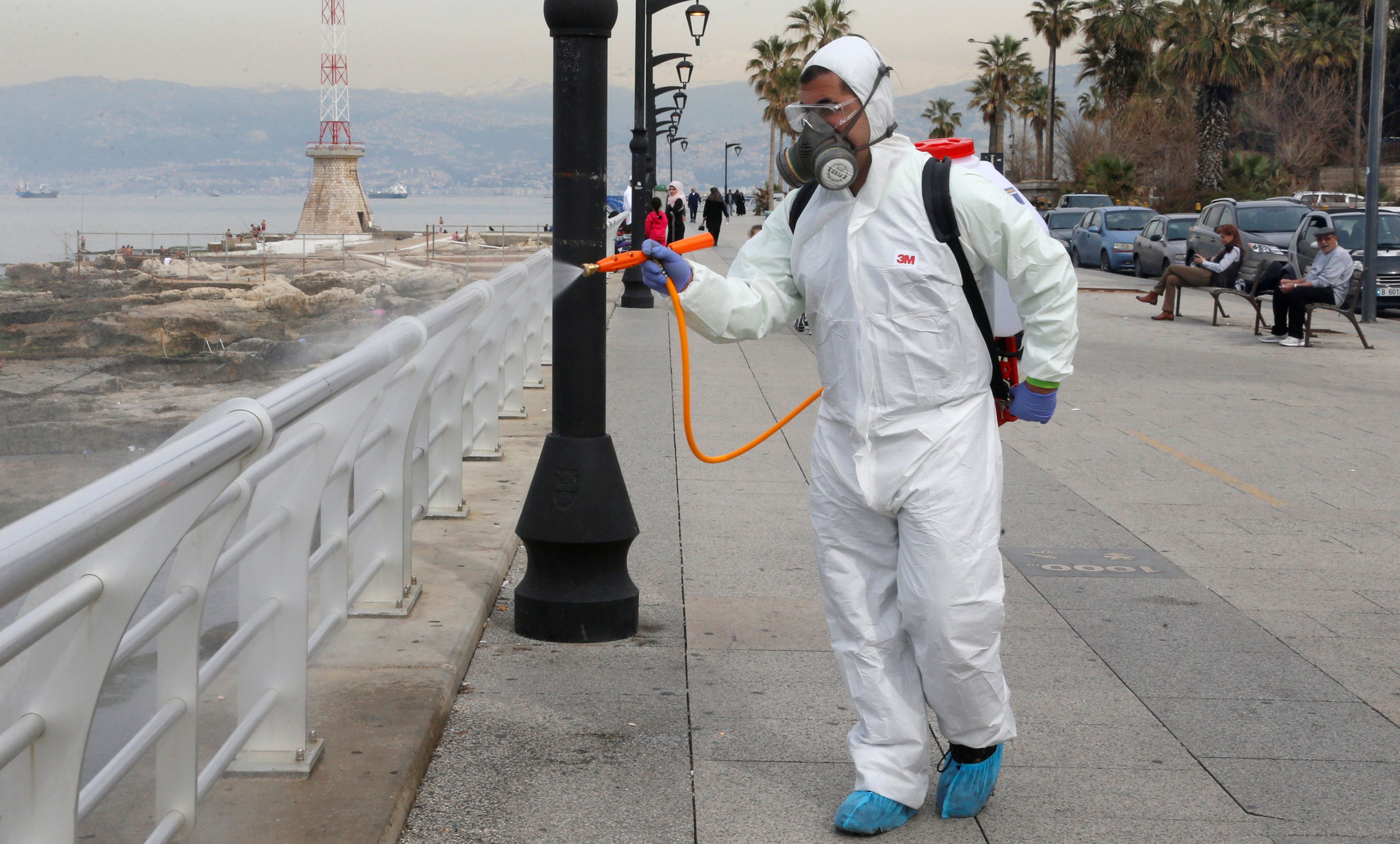 Un trrabajador del Ministerio libanés de Sanidad desinfecta la barandilla del paseo marítimo de Beirut