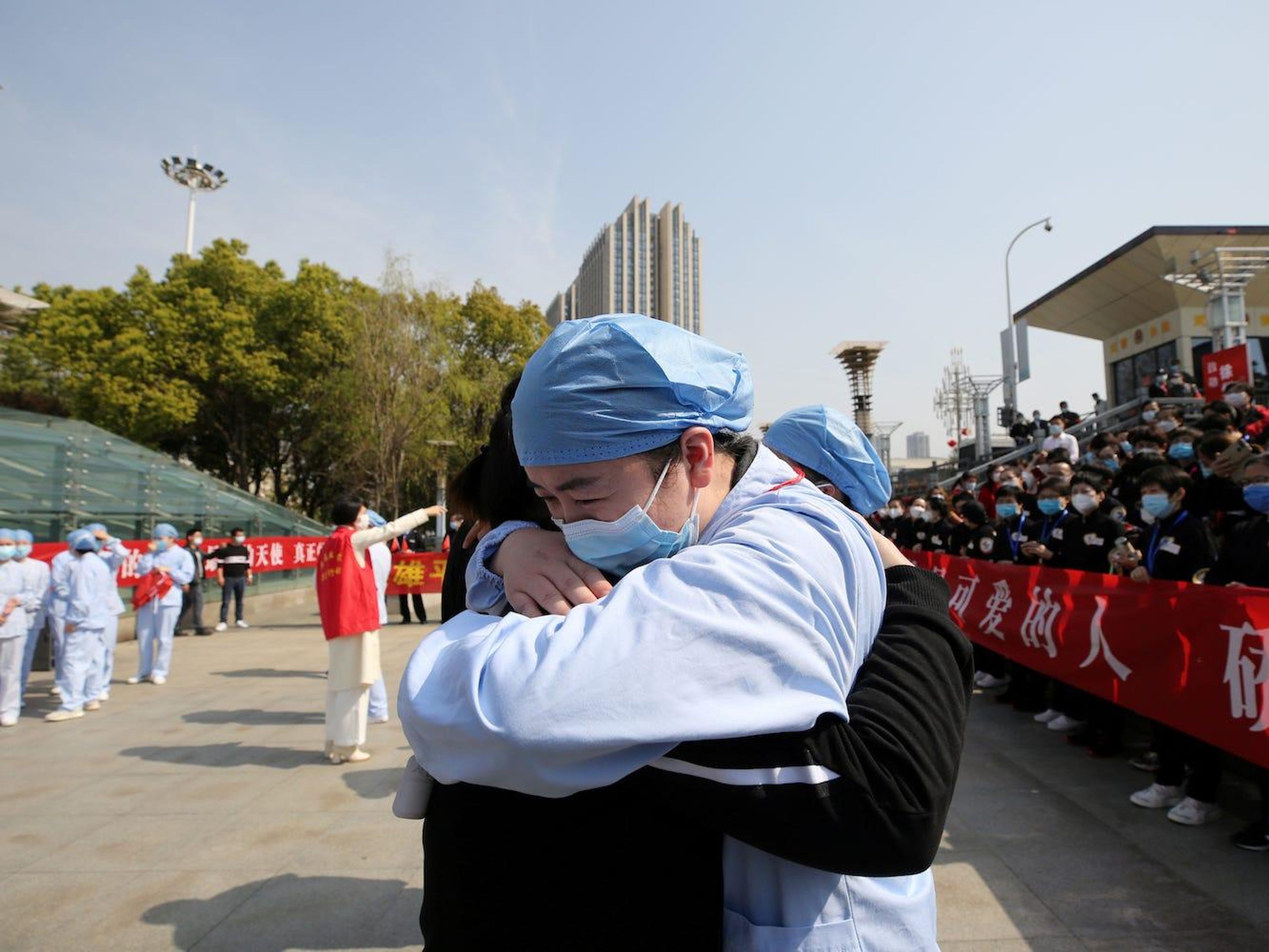 Un trabajador sanitario local se abraza y se despide de un médico de Jiangsu en la estación de tren de Wuhan el 19 de marzo de 2020.