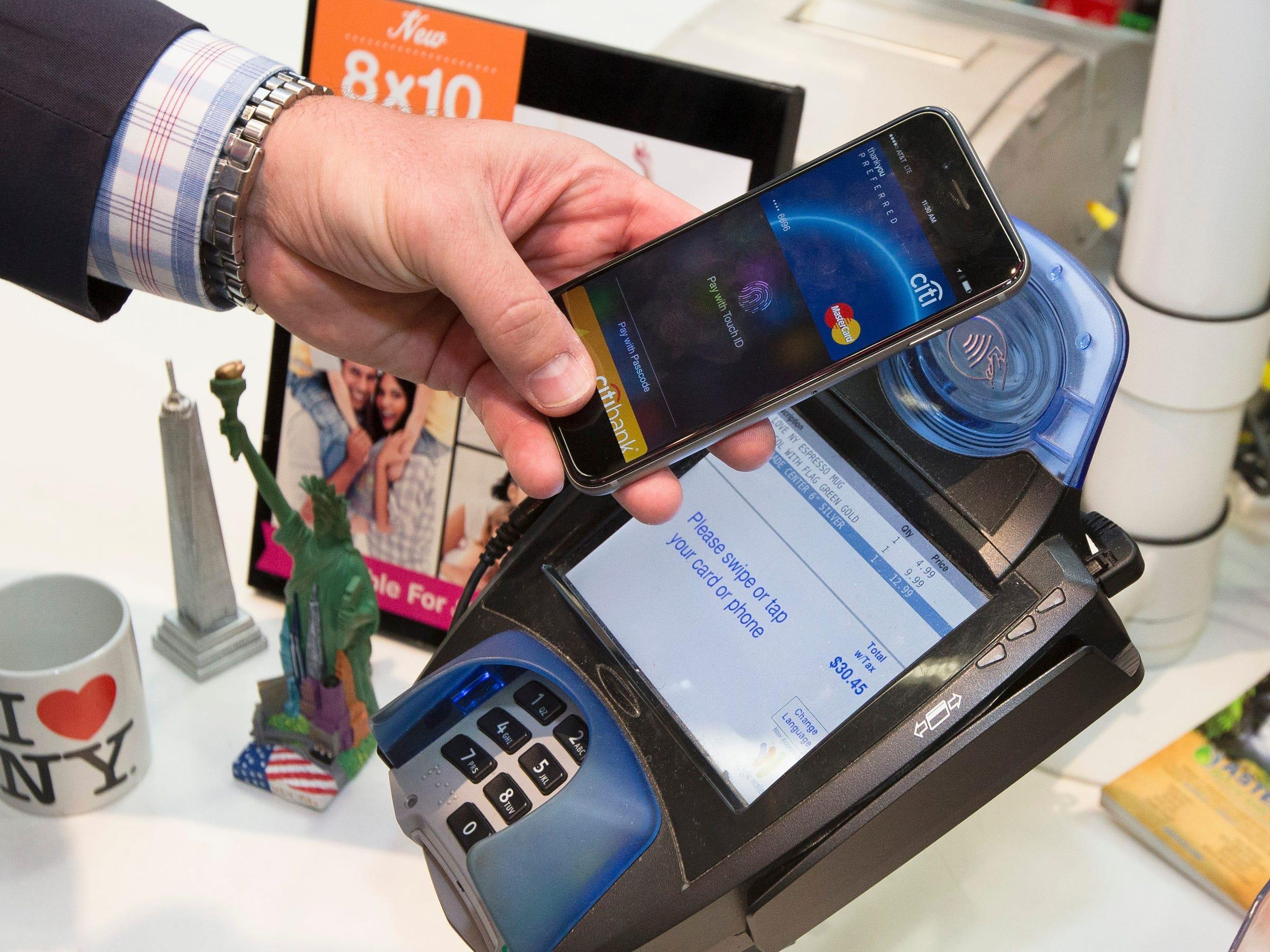 Un cliente hace una compra con una MasterCard usando Apple Pay en el iPhone 6.