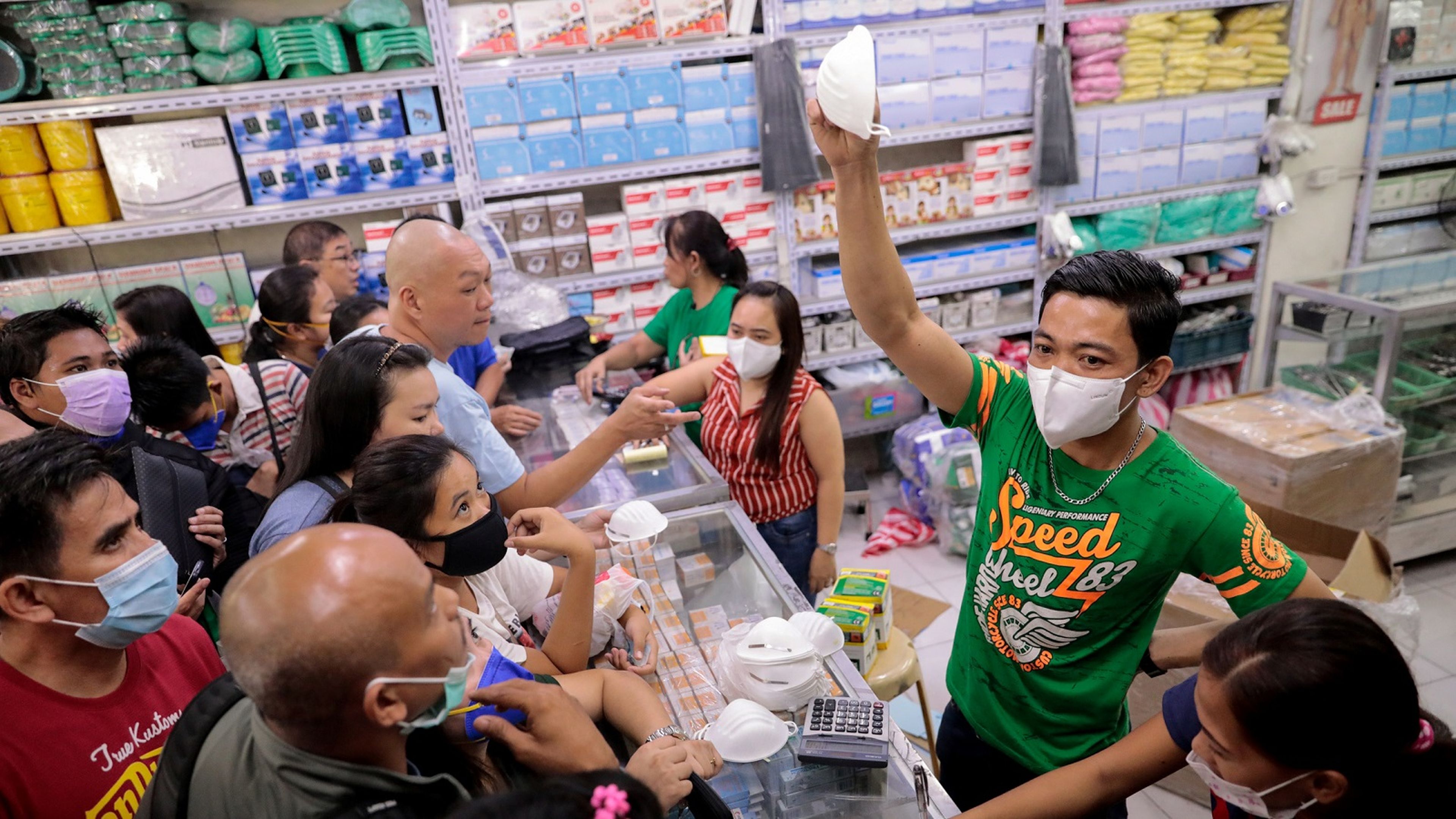Un vendedor muestra su última máscara disponible en una tienda durante el brote de coronavirus.