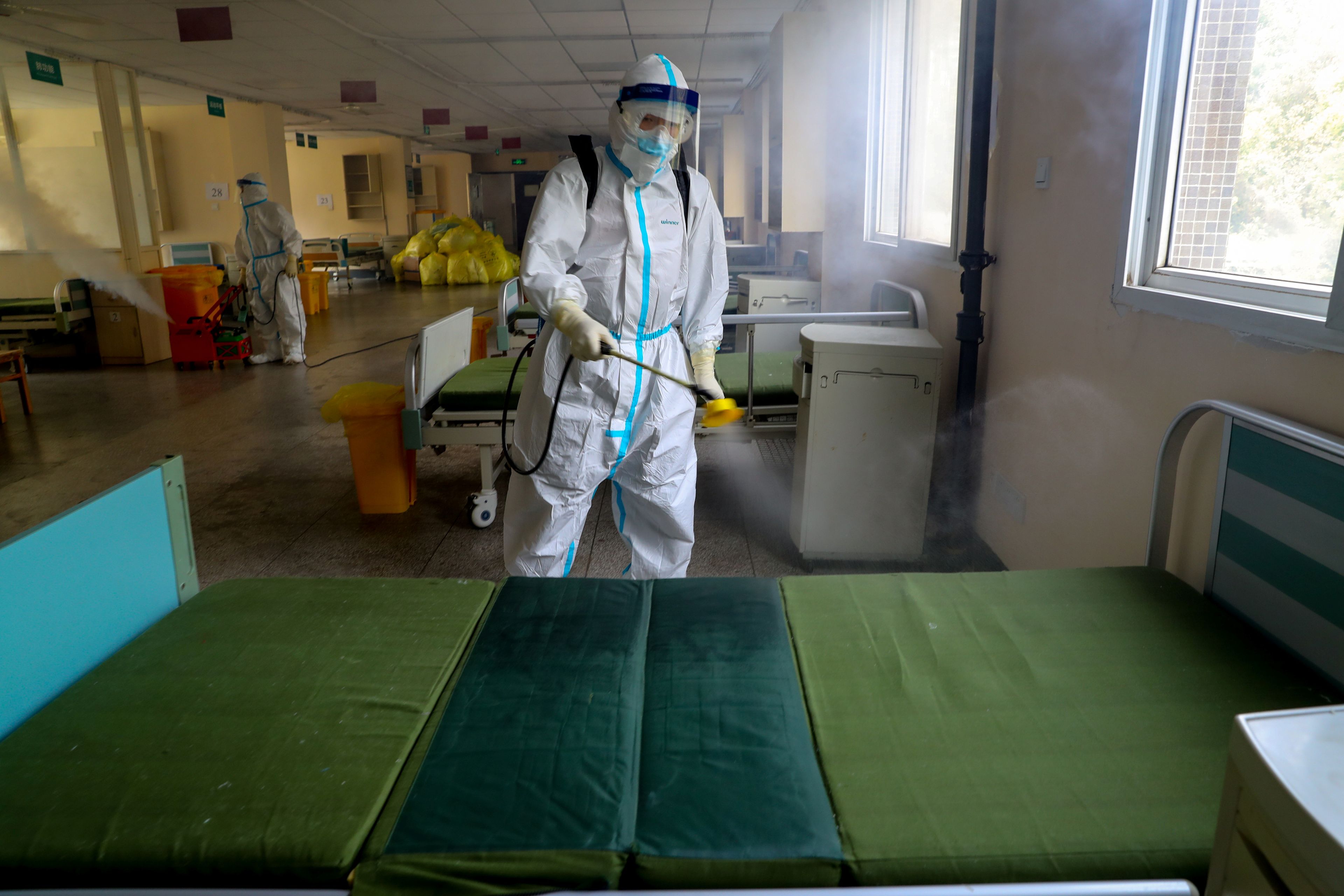 Un trabajador desinfecta el Hospital Wuhan No. 7 designado para pacientes con coronavirus (COVID-19), para prepararlo para la reanudación de su servicio normal en Wuhan, China, el 19 de marzo de 2020.