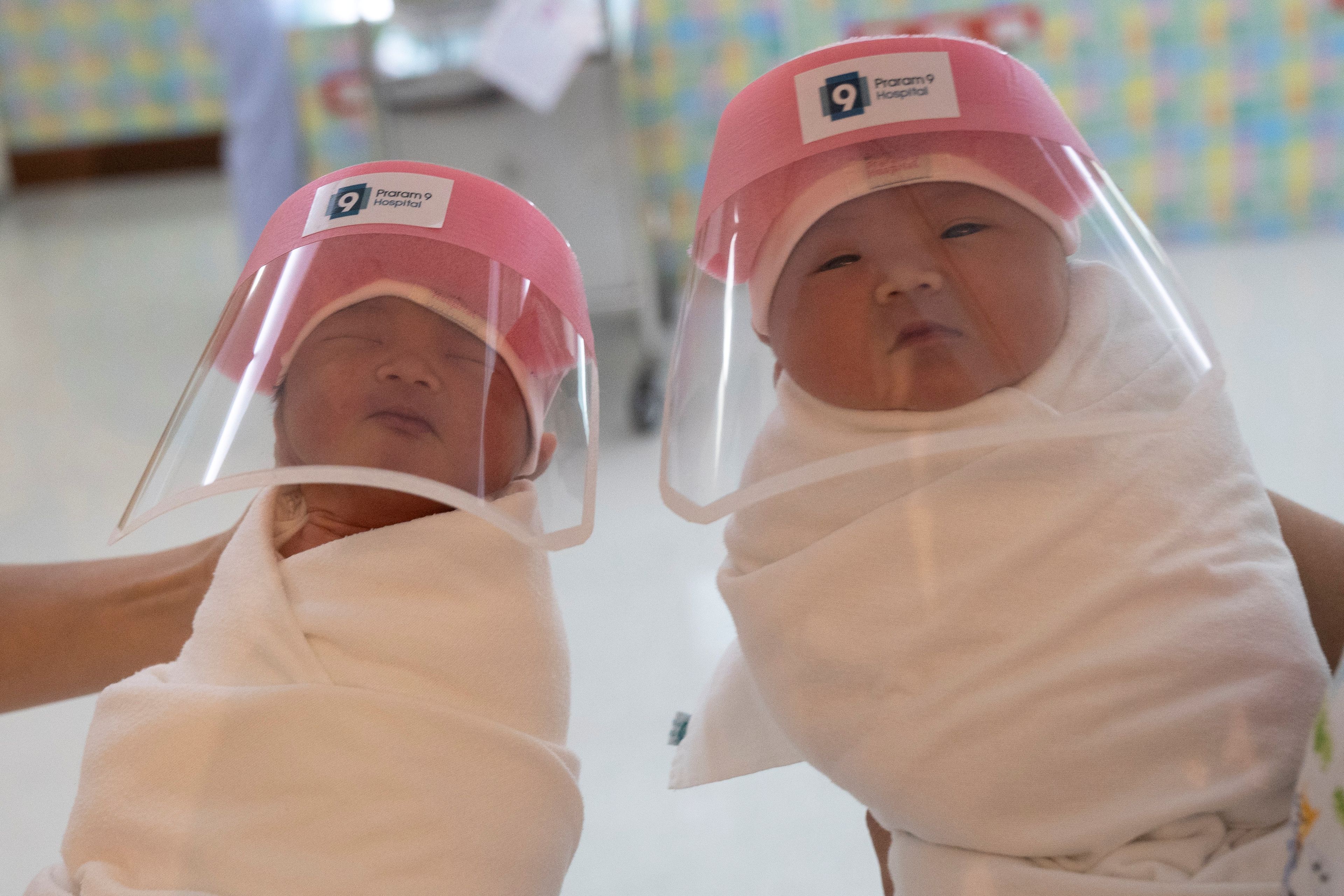 Dos recién nacidos en Bangkok, protegidos con máscaras ante el avance de la pandemia del coronavirus.